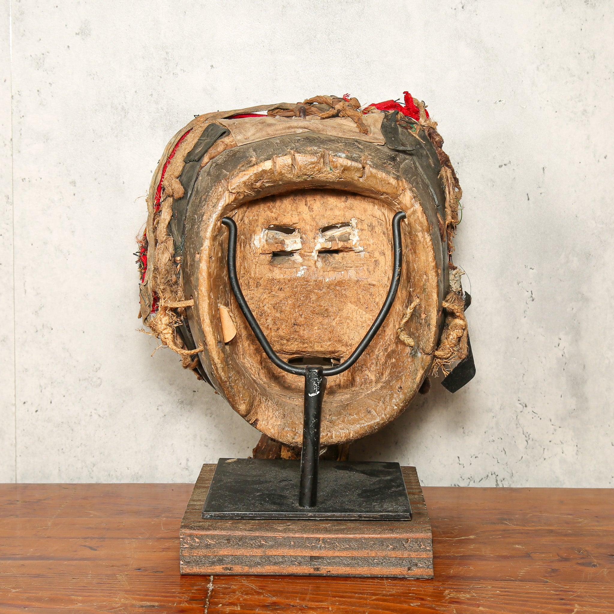 Dan Mask from Côte d’Ivoire as a home decor idea on a stand showing back side