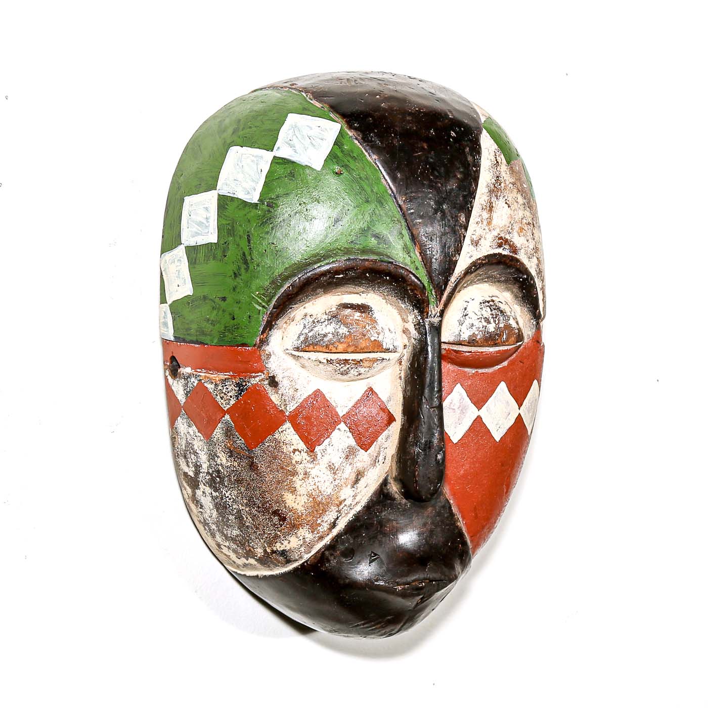 Colorful Aduma African wood mask with geometric patterns on a white bedroom wall