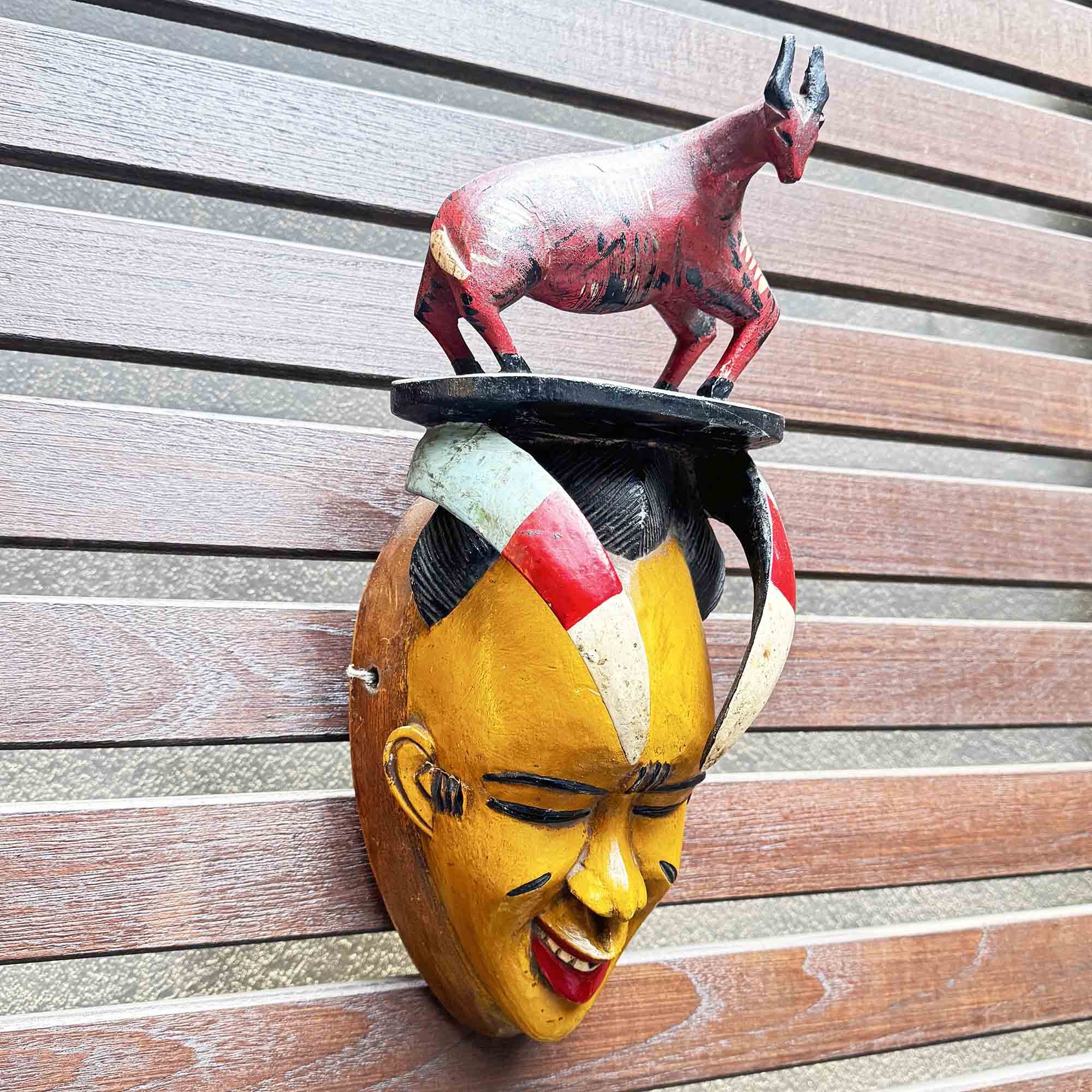 African mask with unique hang-made bull on the head handing on a wall