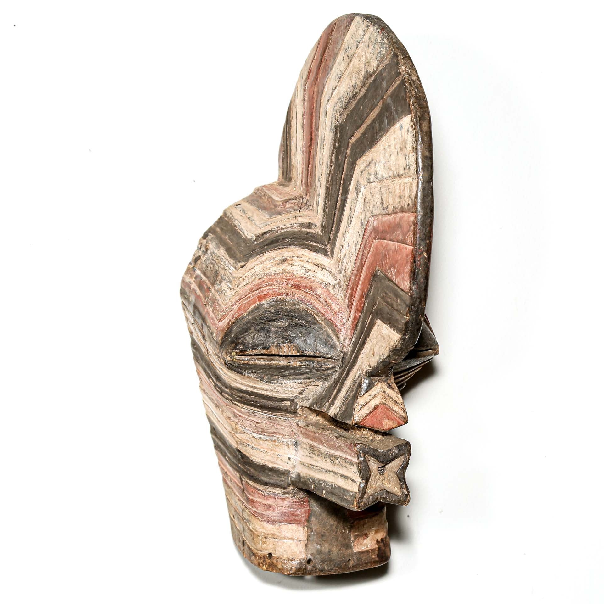 colorful Wooden African mask with striped pattern hanging on a white wall for sale