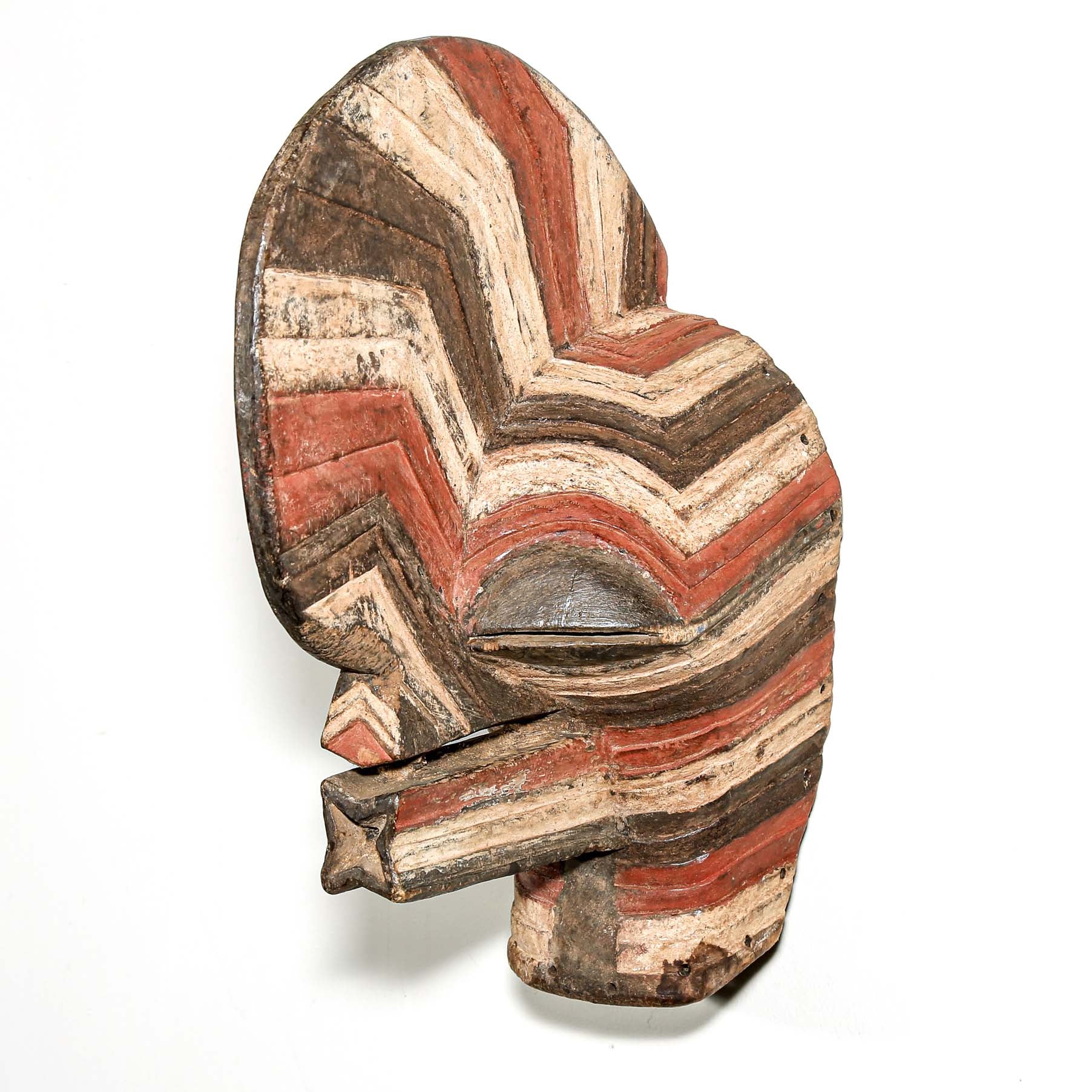 colorful Wooden African mask with striped pattern hanging on a white wall for sale