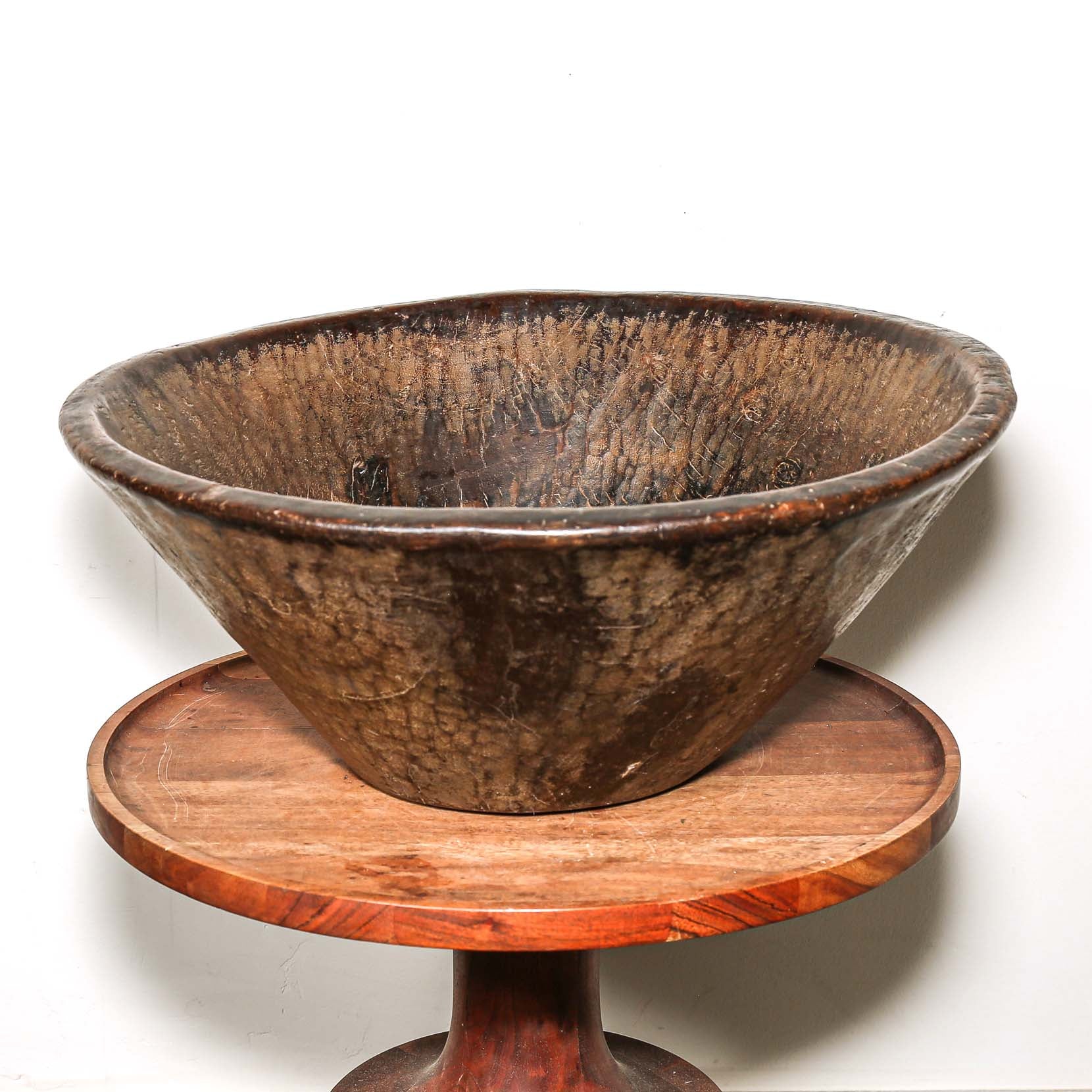 Wooden bowl on a wooden stand against a white background