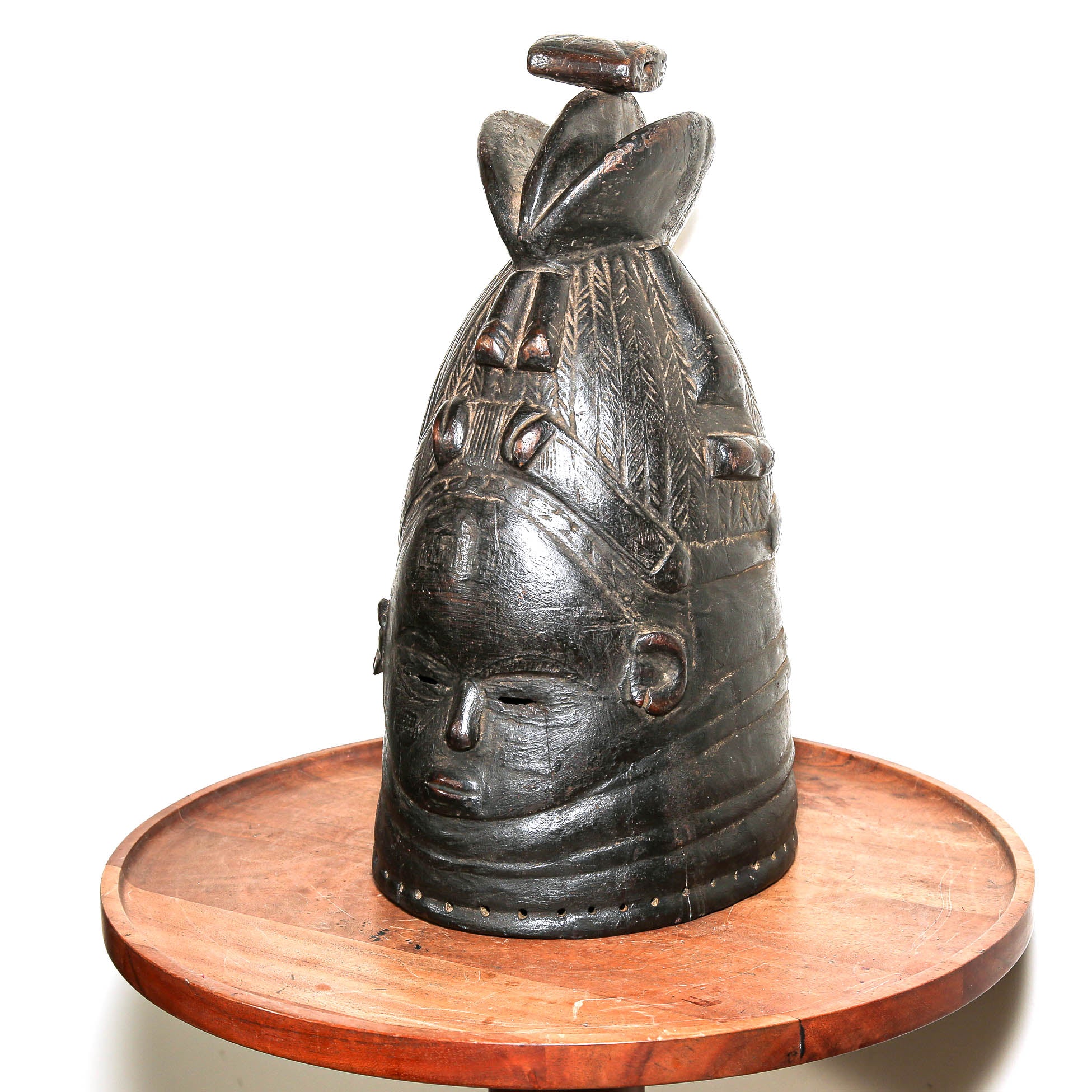 Black Mende helmet mask from Sierra Leone displayed on a side table