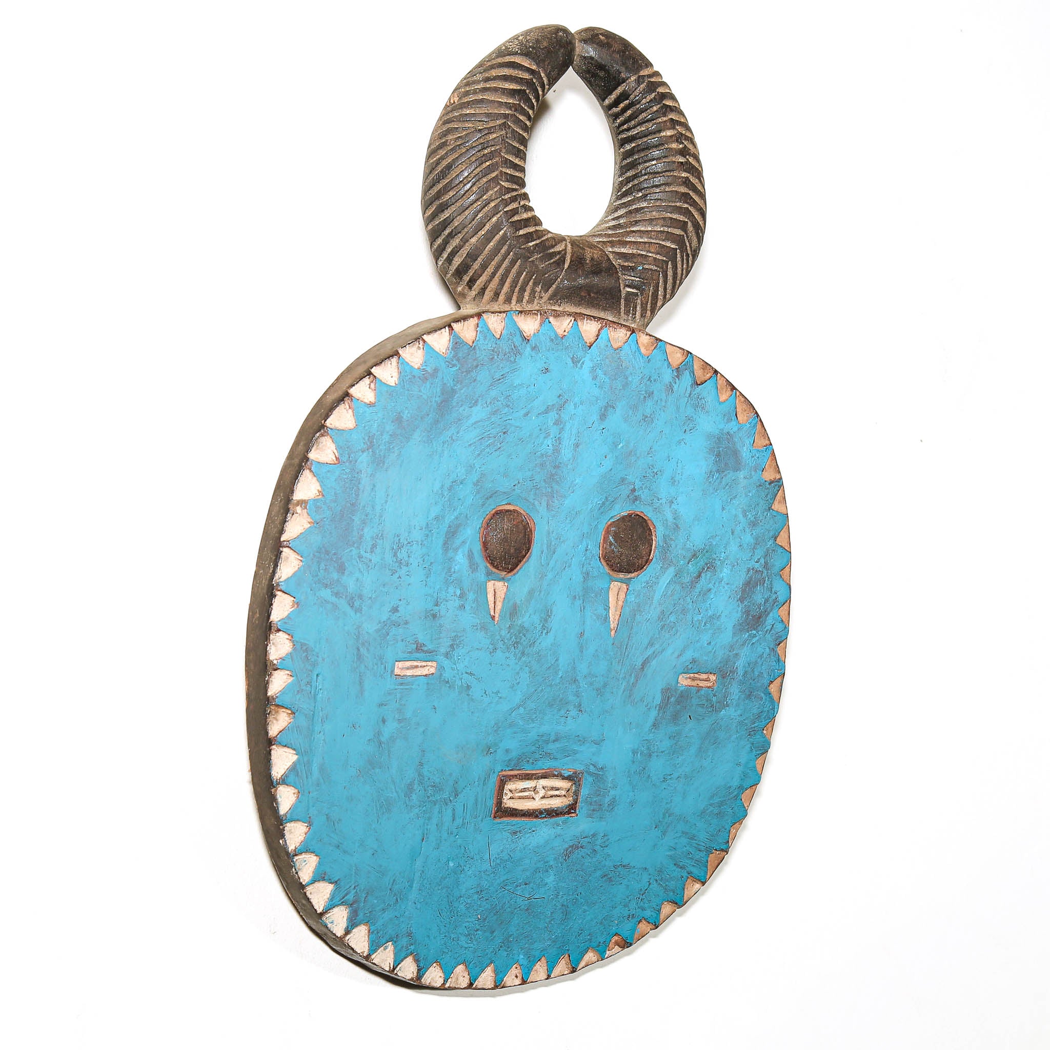 A hand-carved African wooden mask with a curved horn-like top and a turquoise blue painted face, featuring white painted details and a scalloped wooden border, shown against a plain white background.