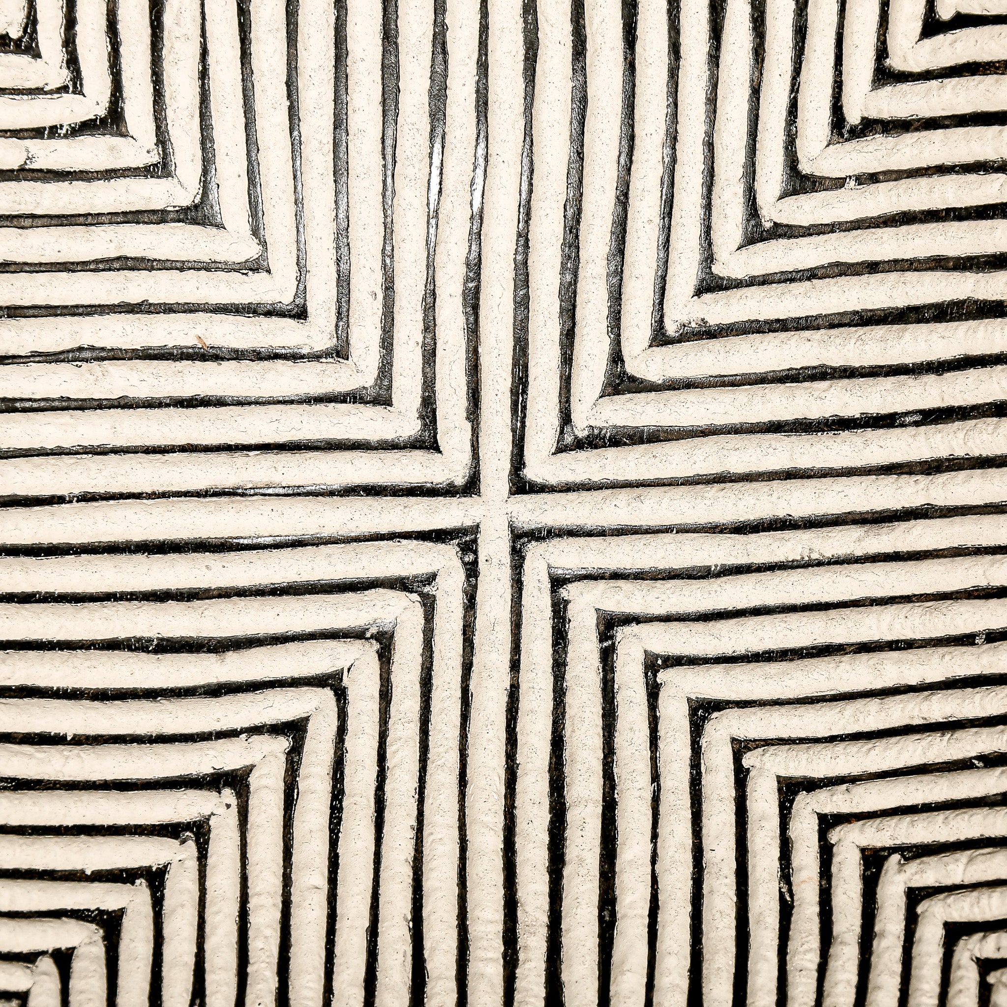 Round wood wall decor with rustic African traditional striped pattern on a white living room wall