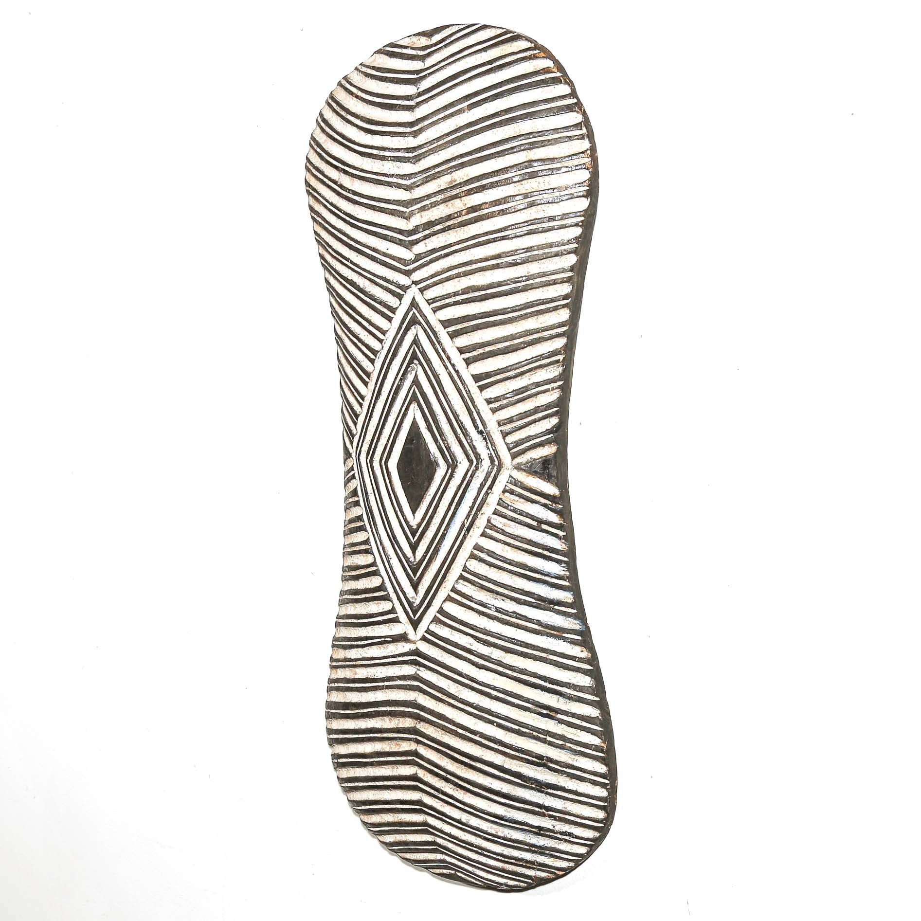 Decorative wall art from Africa with geometric pattern on a white home wall