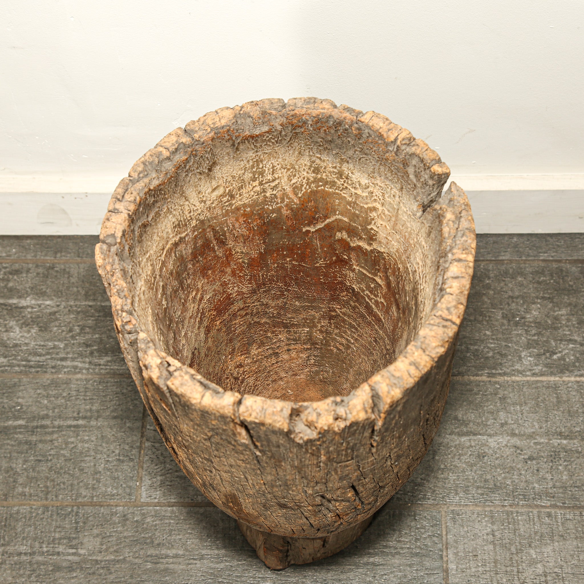 Vintage wooden barrel on a gray floor with a white wall background