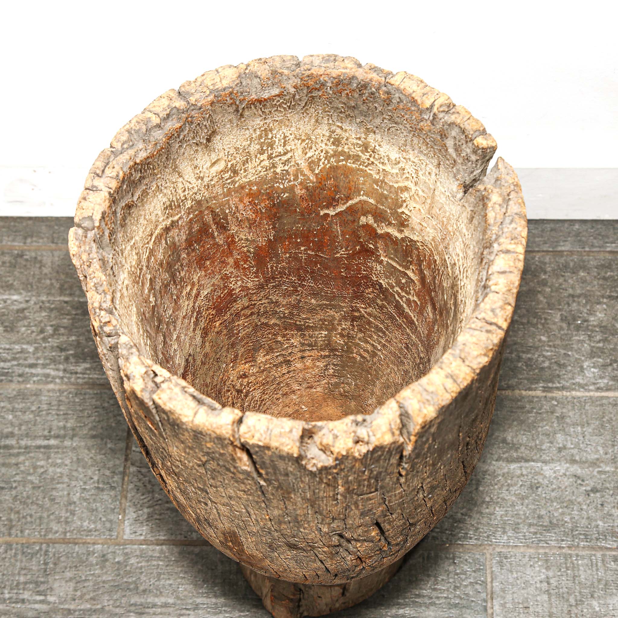 Wooden basin with a textured surface on a wooden floor
