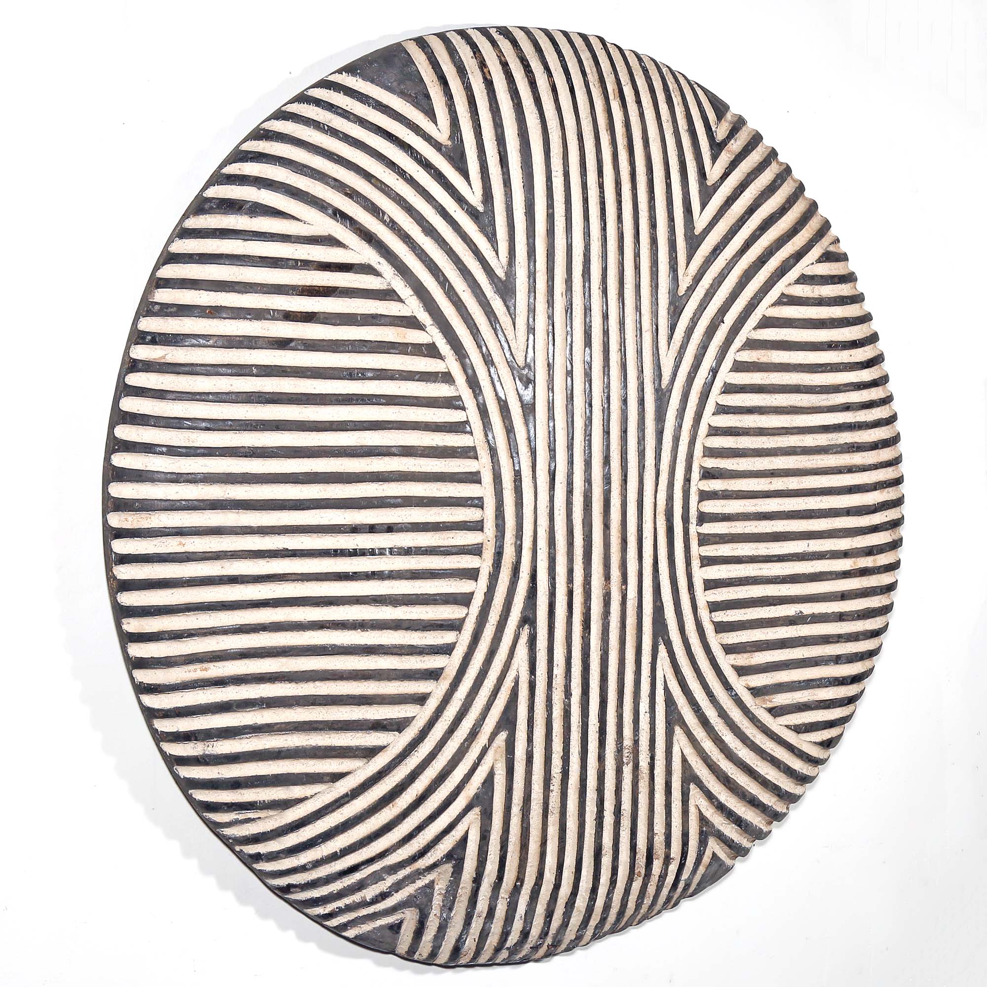 Round wood African art wall hanging for sale with black and white striped pattern on a white background living room design