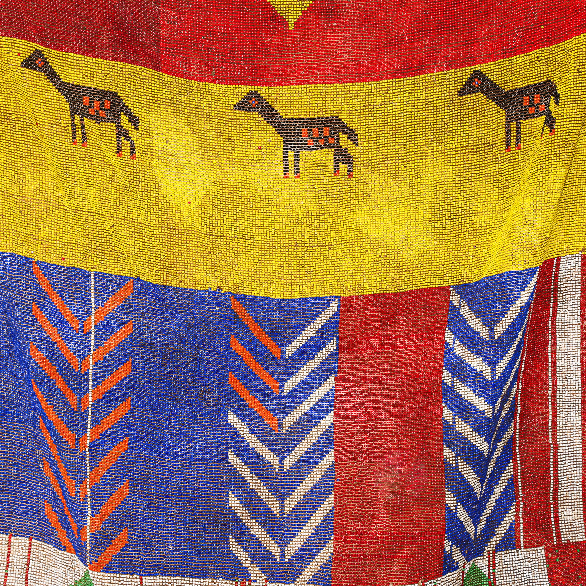 Textile with geometric patterns and animal figures on a red, yellow, and blue background