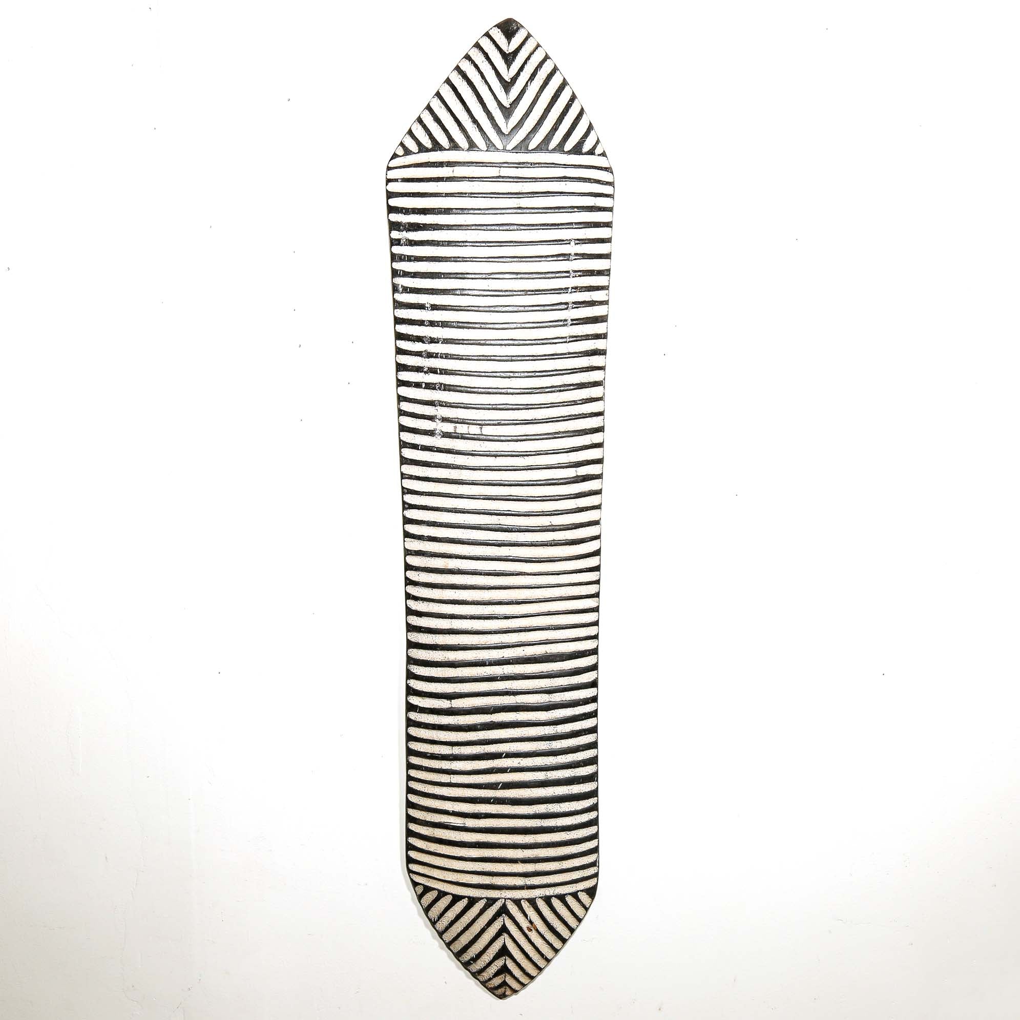 Black and white striped carved wood shield for wall design on a white background