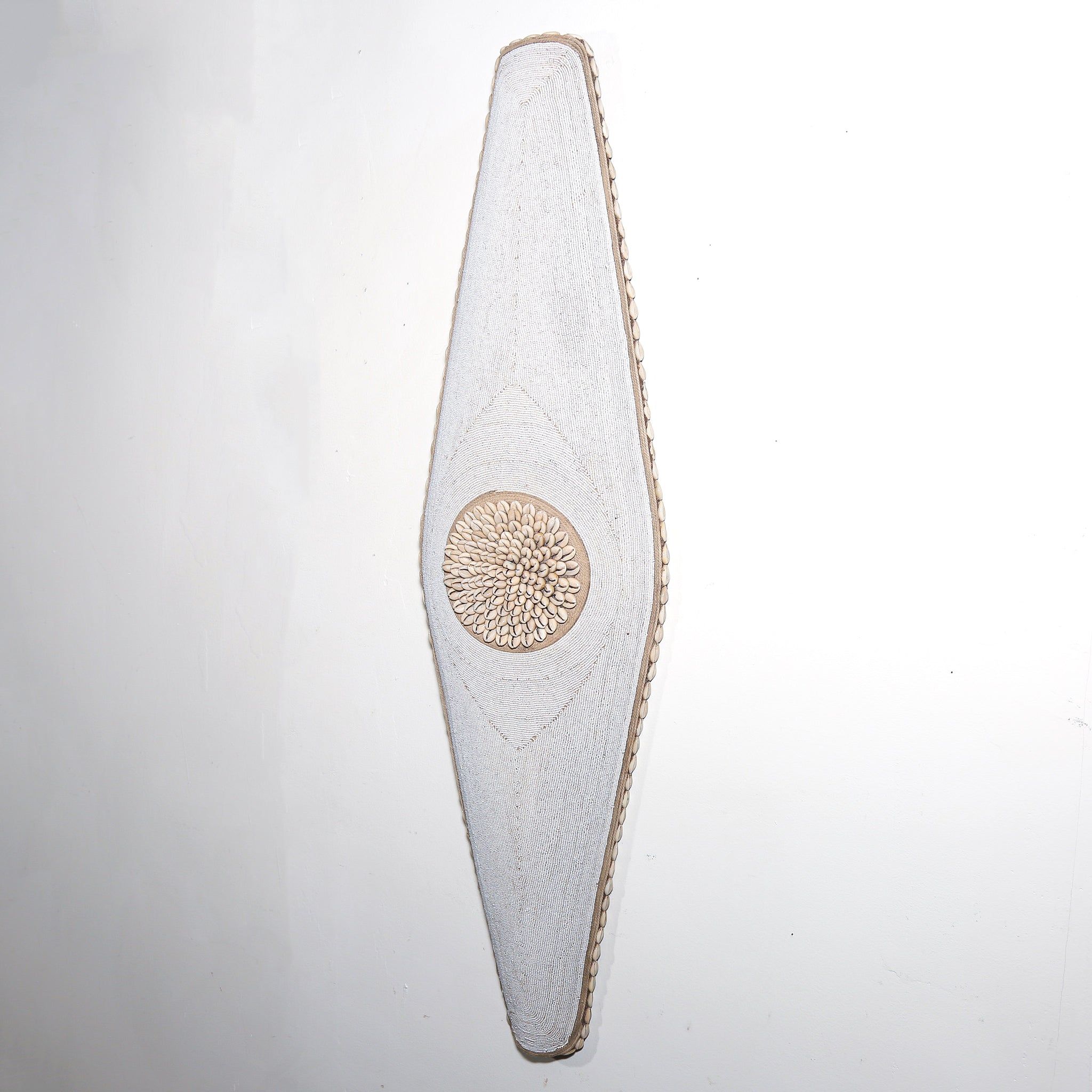 long white shield with white beads and cowrie shells from Cameroon. African Wall art for sale at Hemingway Gallery