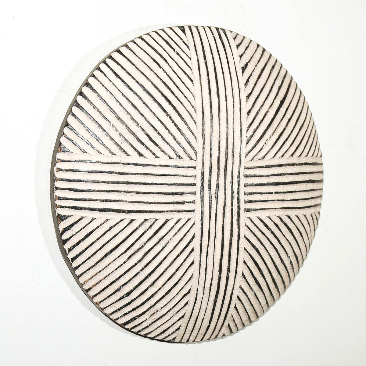 Handcrafted Cameroon shield with a rounded profile and bold decorative patterning for wall display