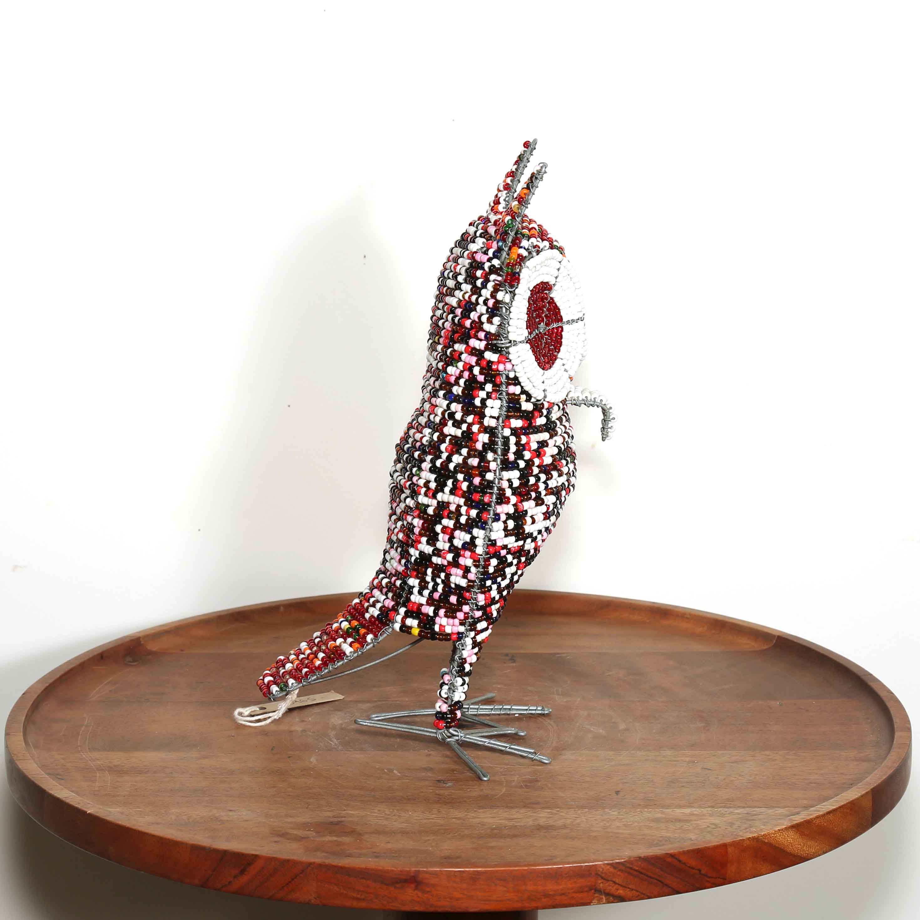 side view of an owl bird sculpture made from wire and beads