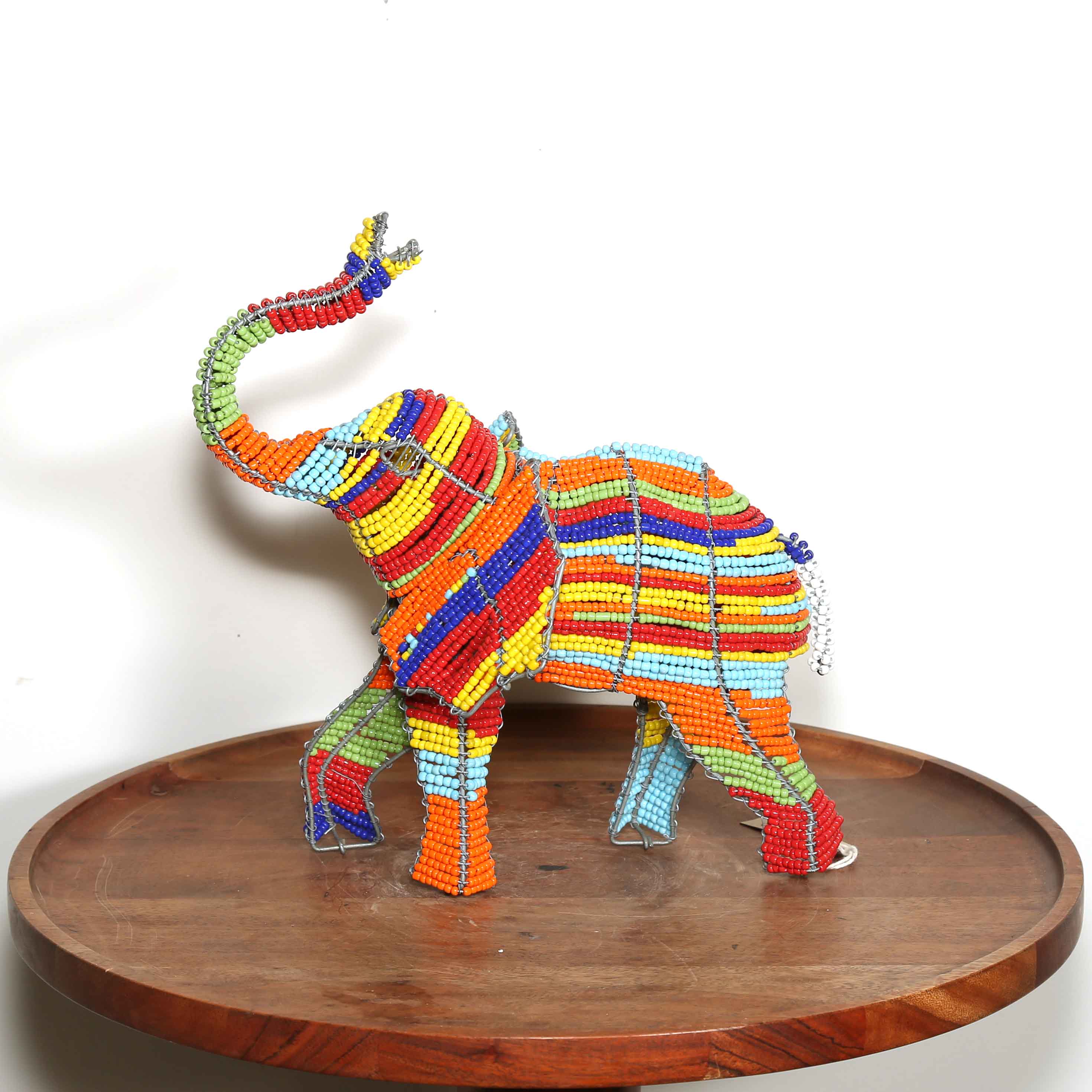 Colorful beaded elephant sculpture on a wooden platform