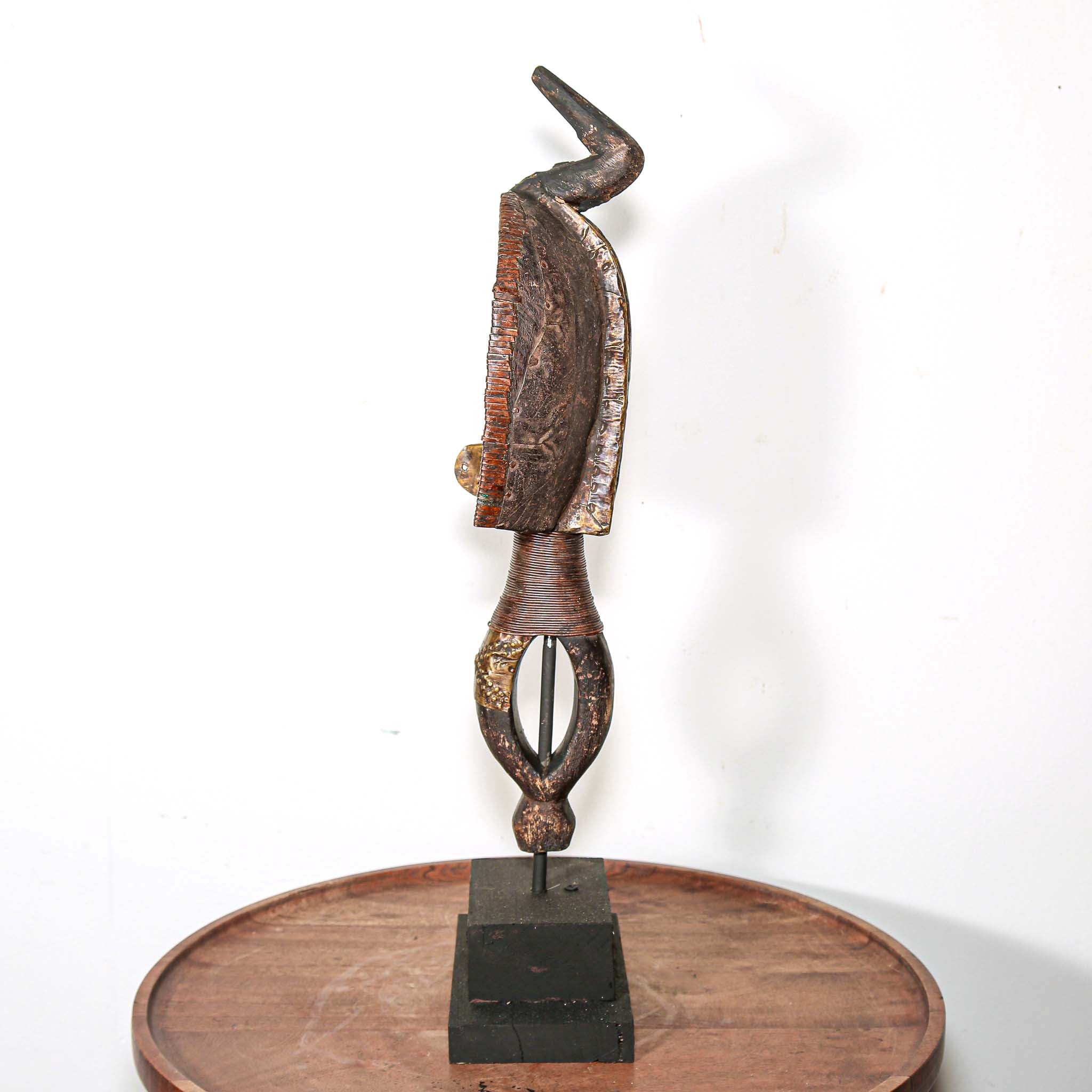 Decorative vintage African art on a stand with a white background