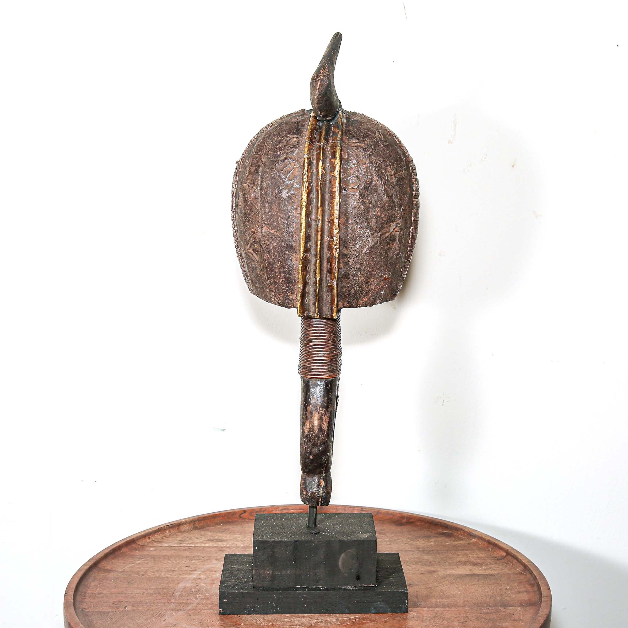 Decorative vintage African art on a stand with a white background