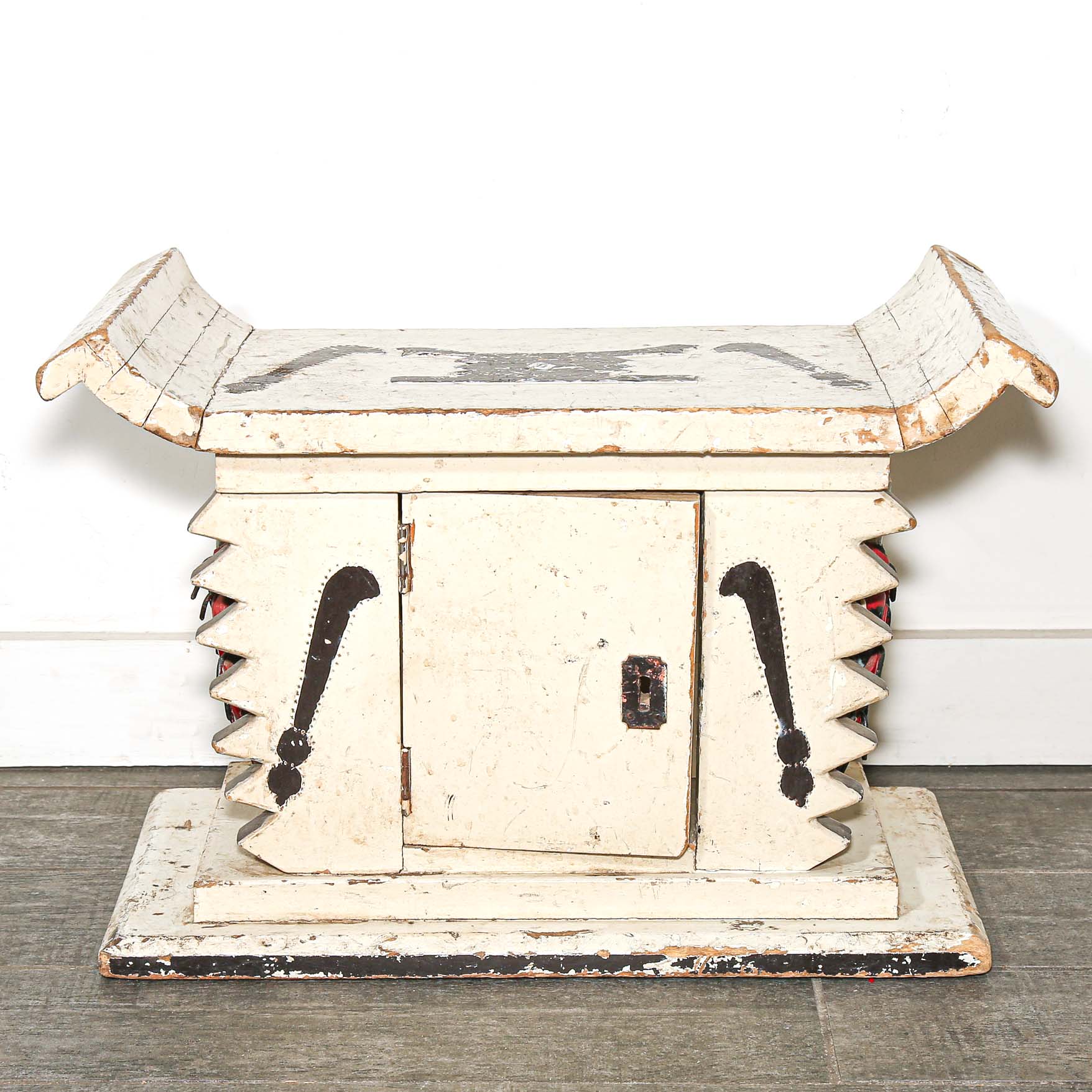 White wooden African stool furniture with cabinet and black accents on a wooden living room floor