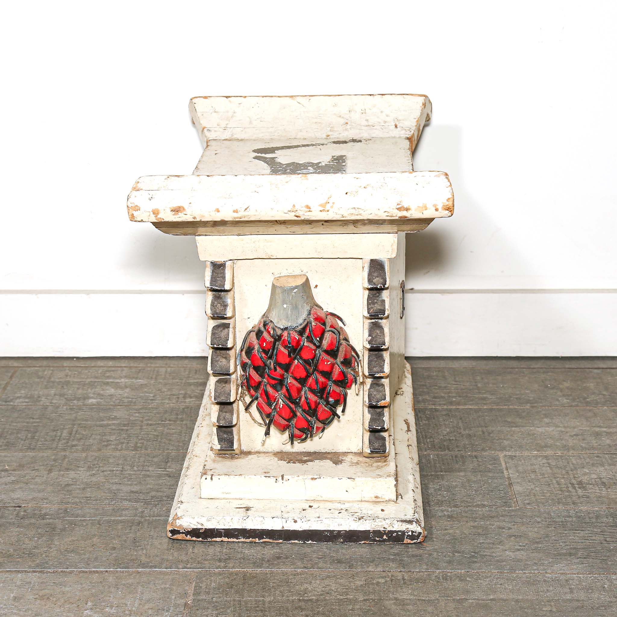 White wooden African stool furniture with cabinet and black distressed accents on a wooden living room floor