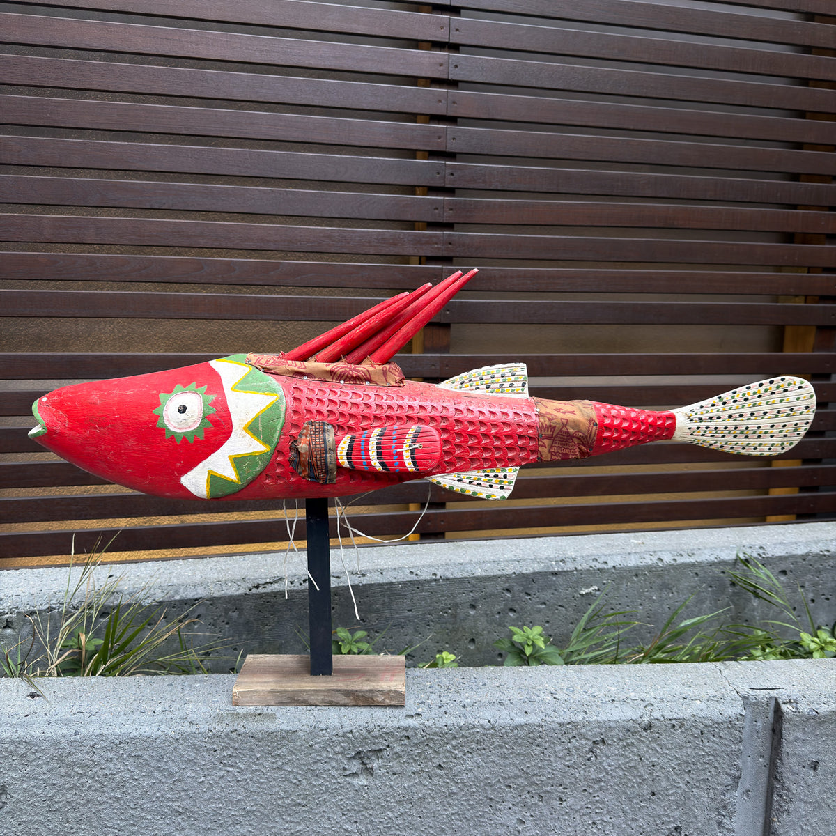 Large red Bozo fish puppet from Mali with an elongated carved body and bold decorative details for African wall display