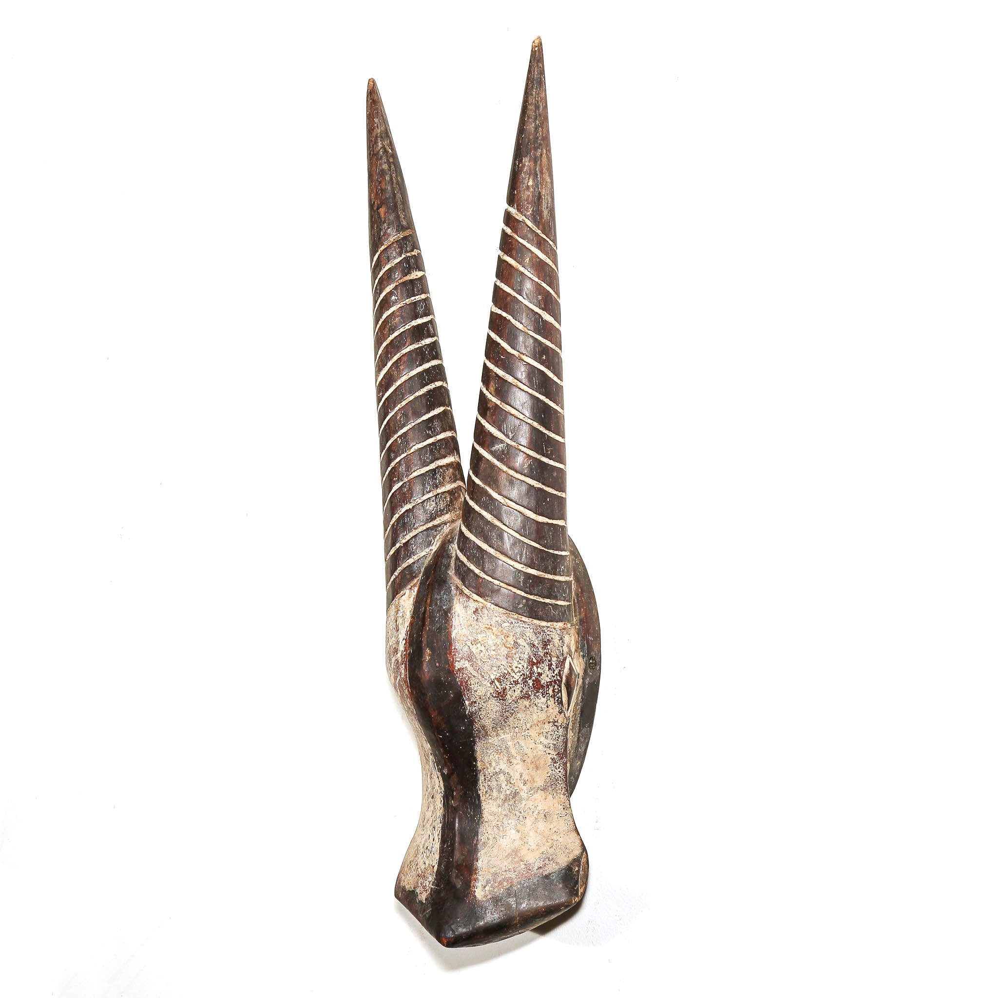 A carved wooden dual-tailed horn ornament with a textured, weathered finish in dark brown and beige tones, featuring carved spiral patterns on the horns, set against a plain white background.