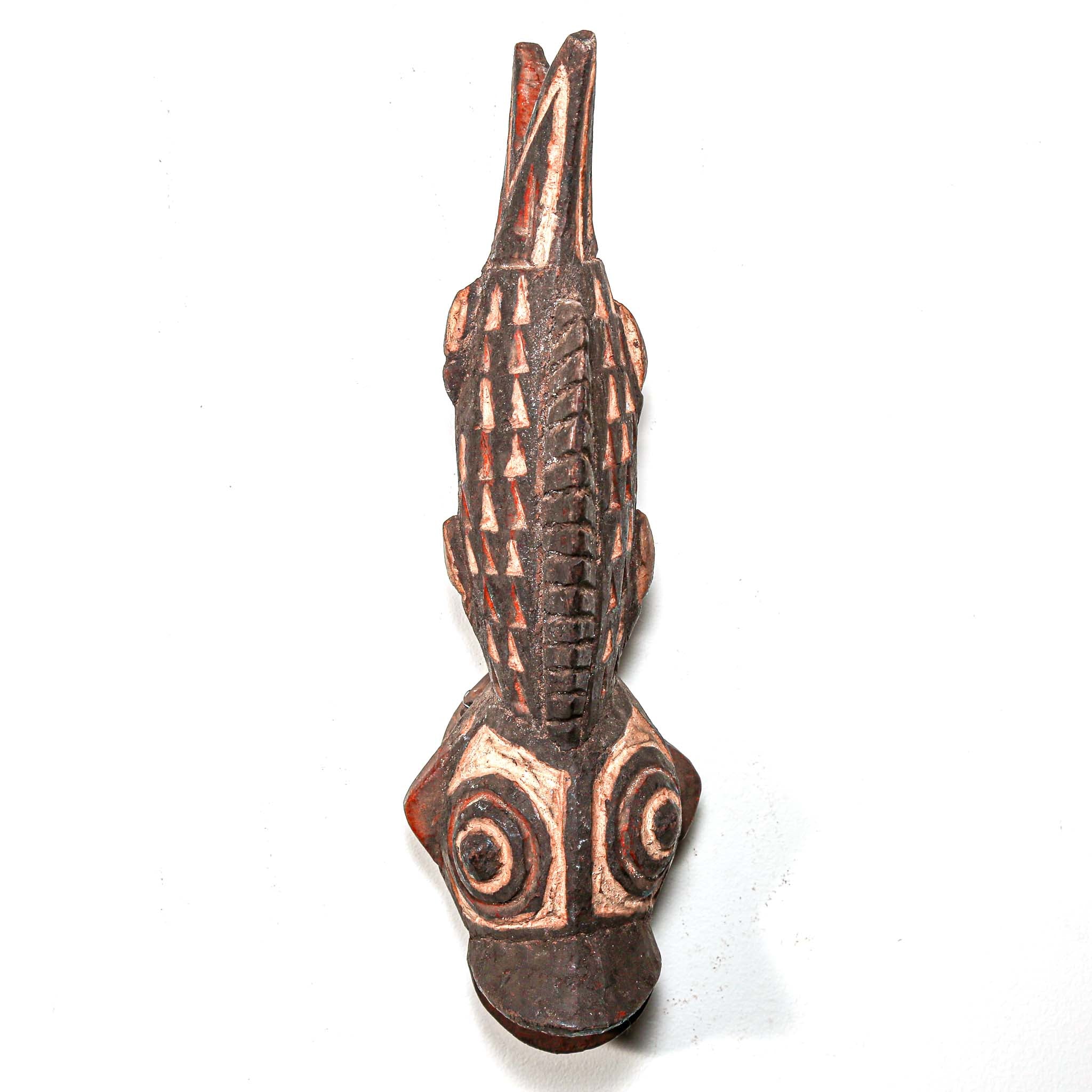 Wooden fish carving from Africa with intricate tribal patterns on a white background