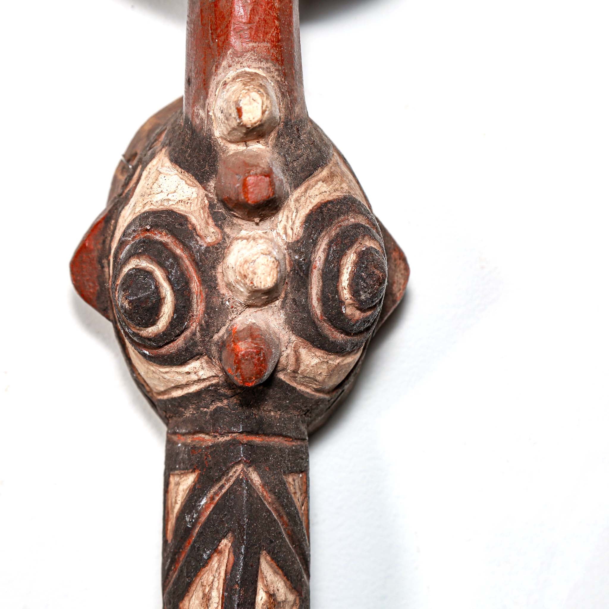 hand made carved wood bird-shaped mask with intricate designs on a white background