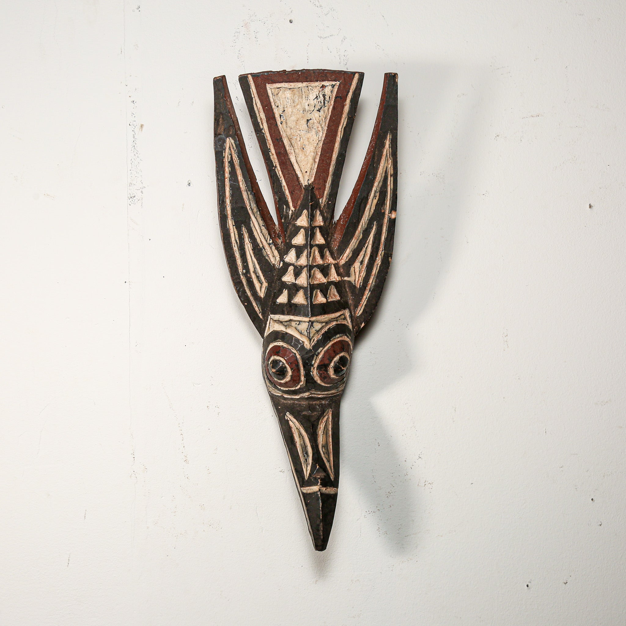 Wooden mask with tribal patterns on a white background