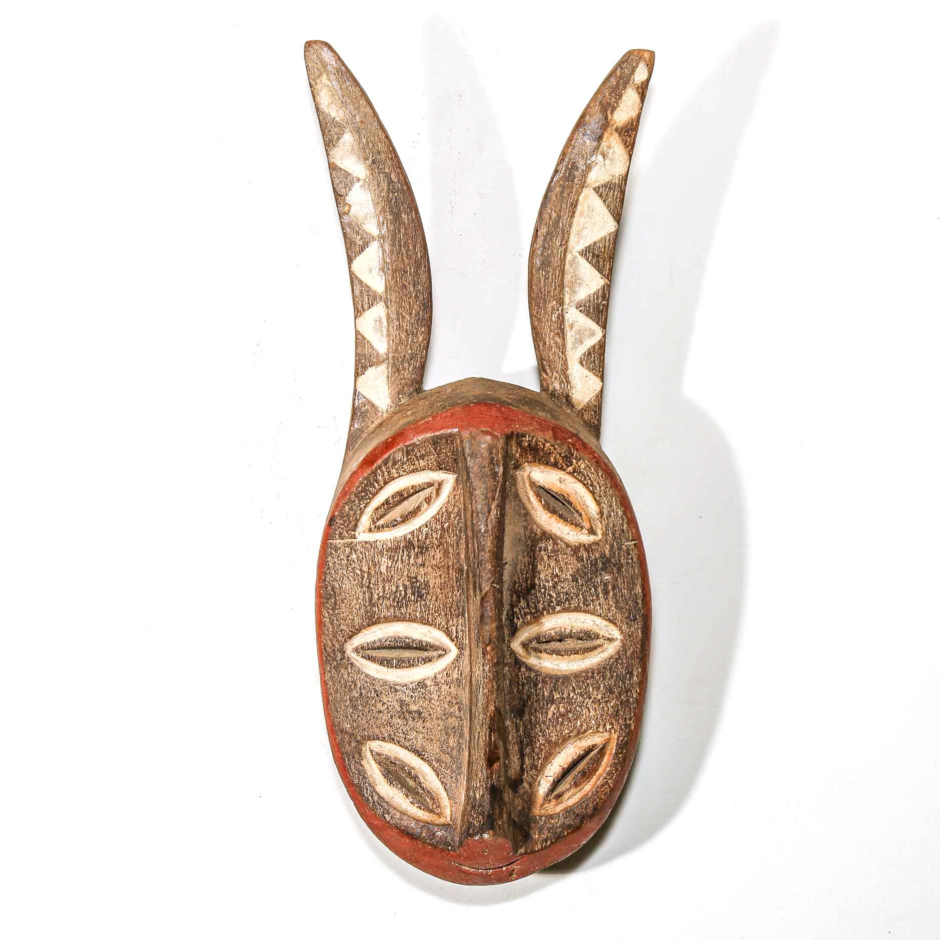 Wooden tribal mask with ears on a white background
