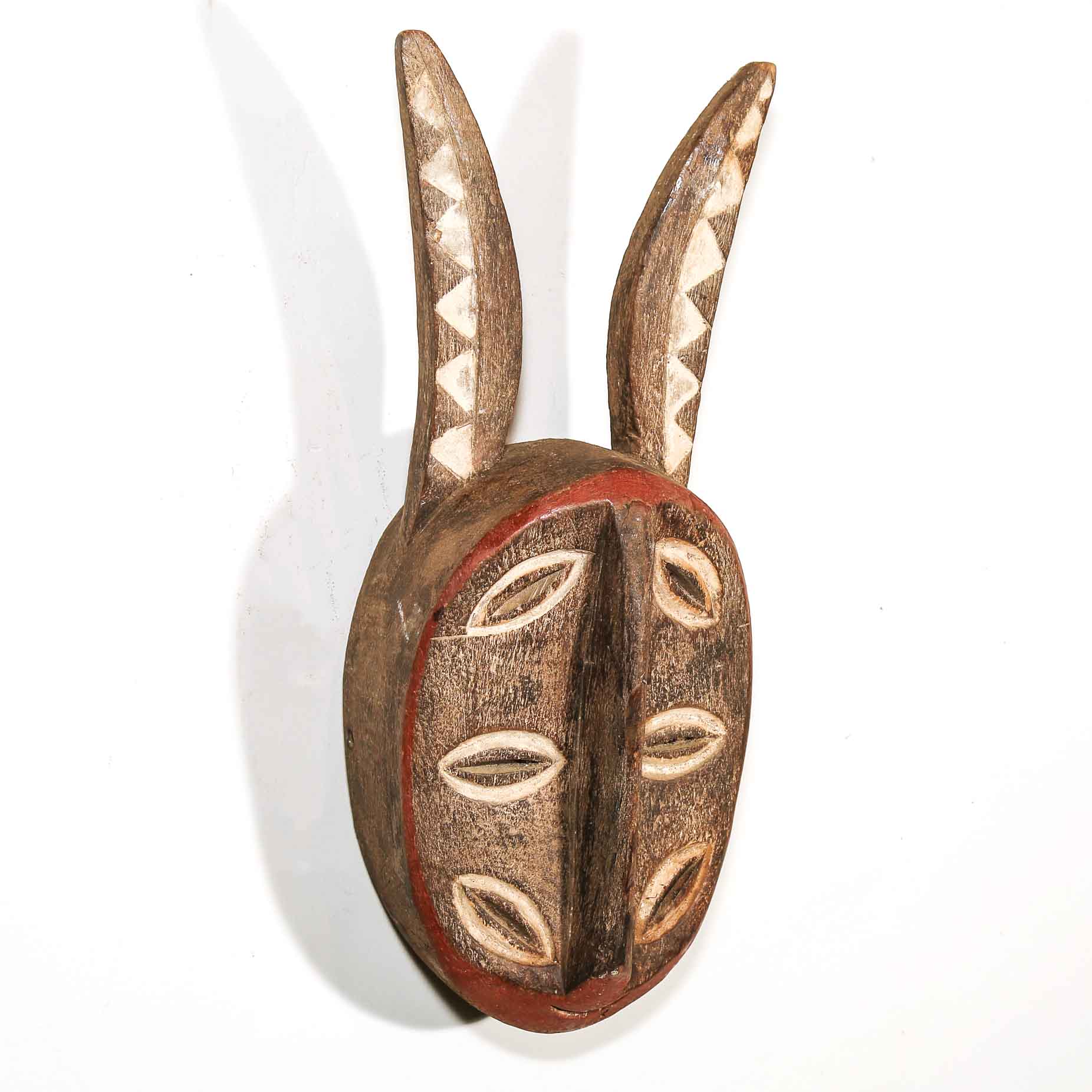 Wooden mask with decorative patterns on a white background