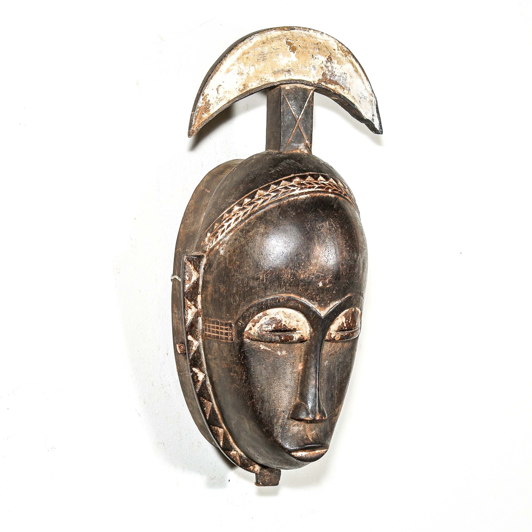 Decorative mask with a crescent moon on a white background