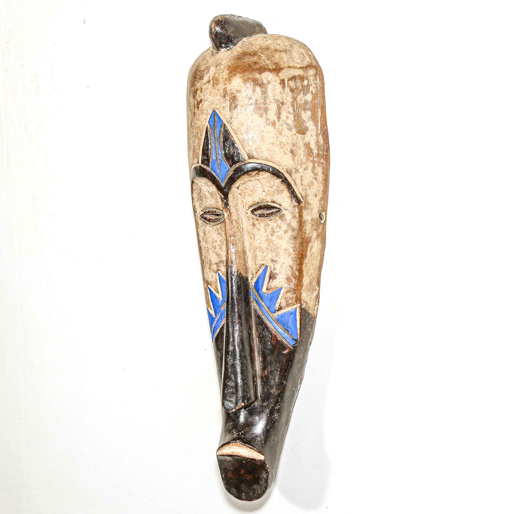 Wooden mask with blue and black designs on a white background