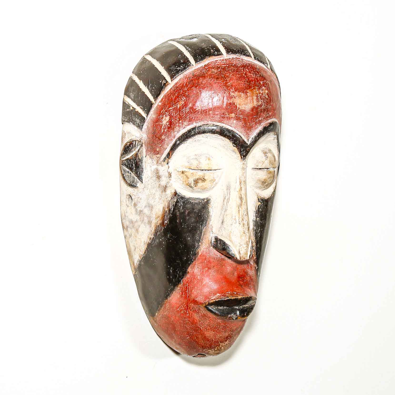 Decorative mask with red, black, and white colors on a white background