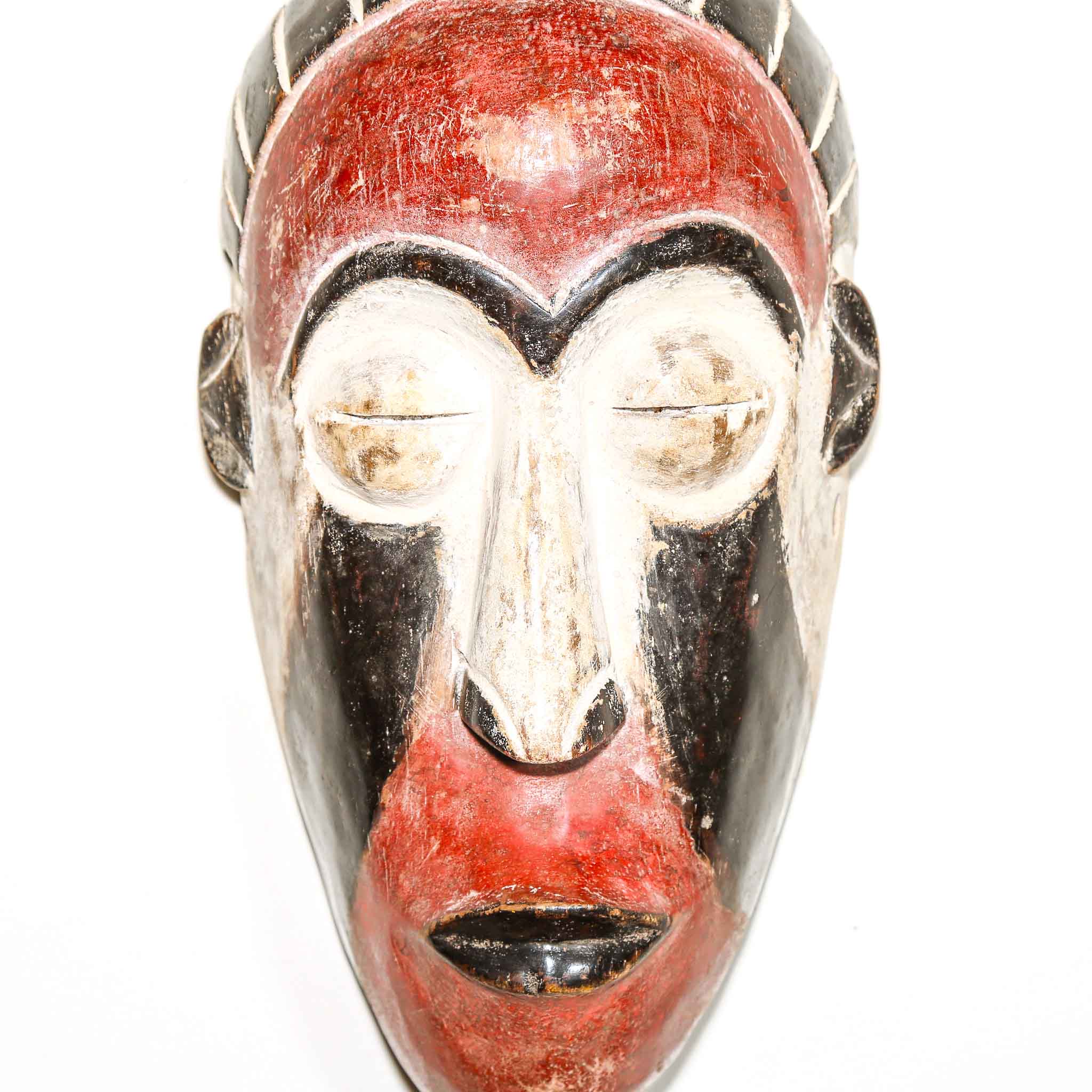 Metallic mask with red and black design on a white background