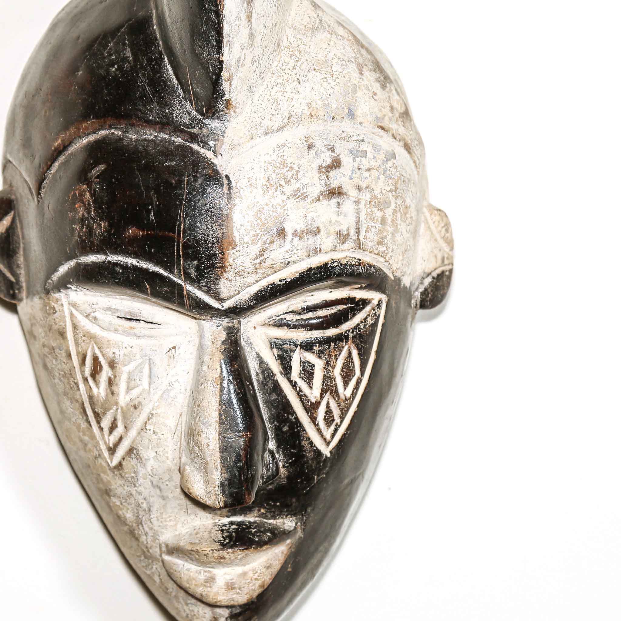 white and black mask with tribal design on a white background