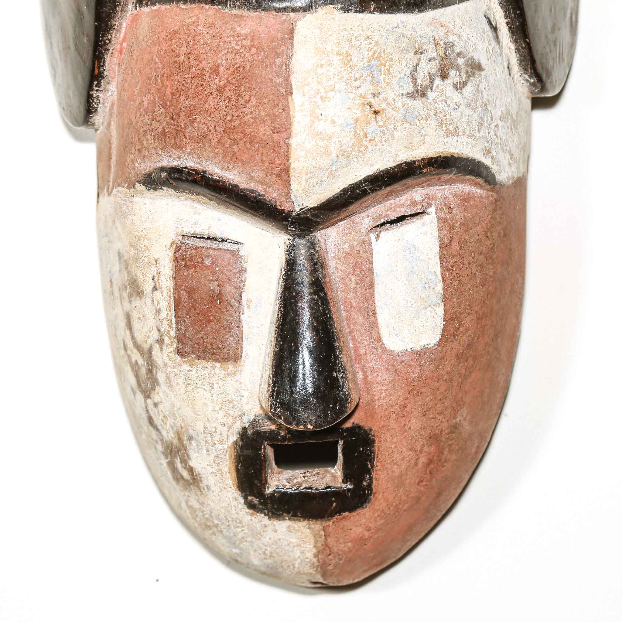 African wood mask with a neutral expression on a white background