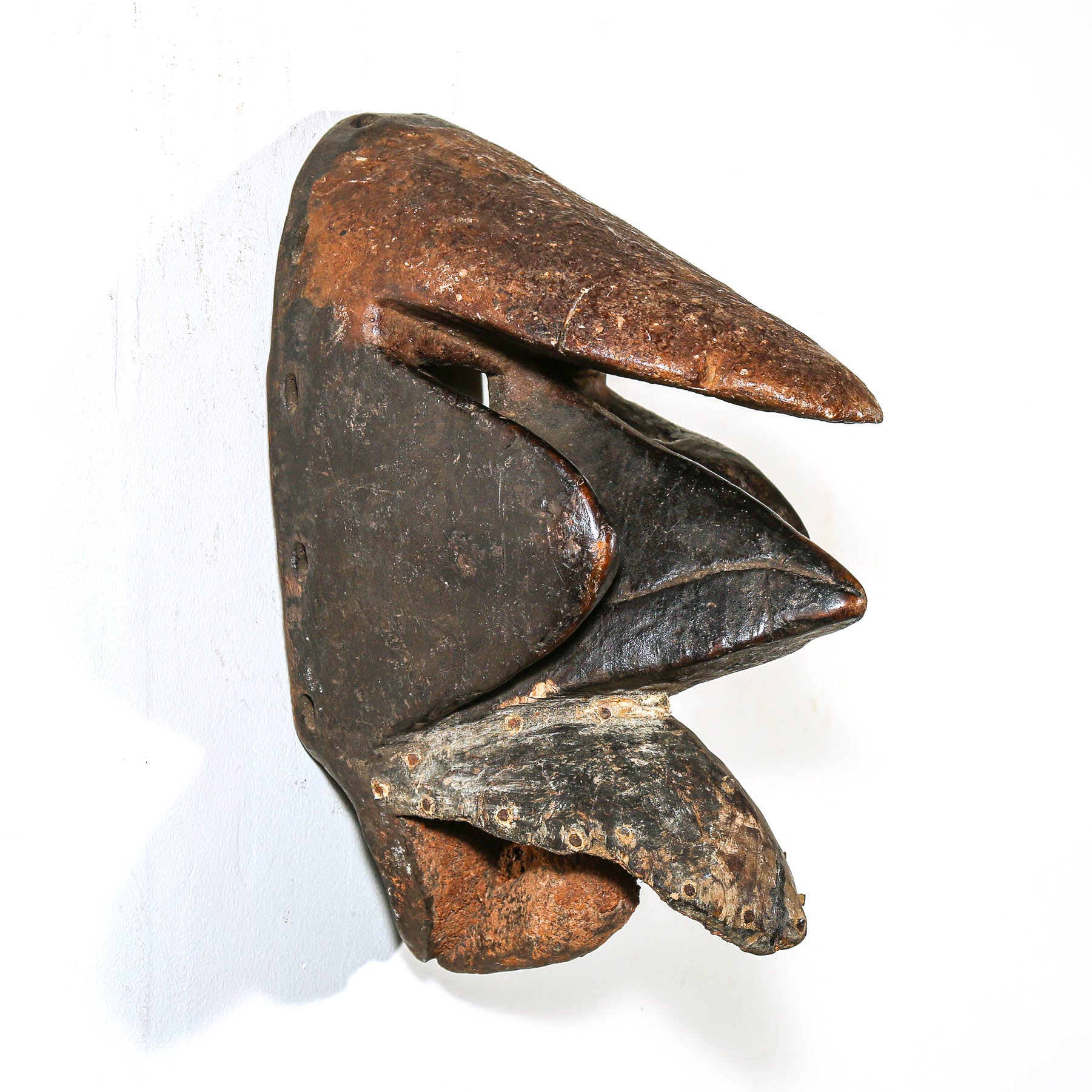 Black African art wood mask with a white collector's wall
