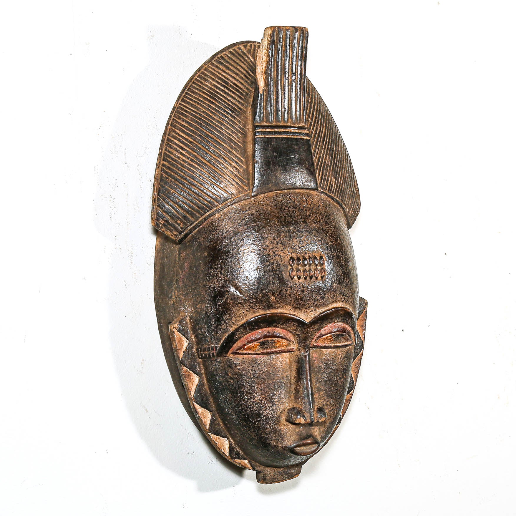 Wooden mask with intricate carvings on a white background