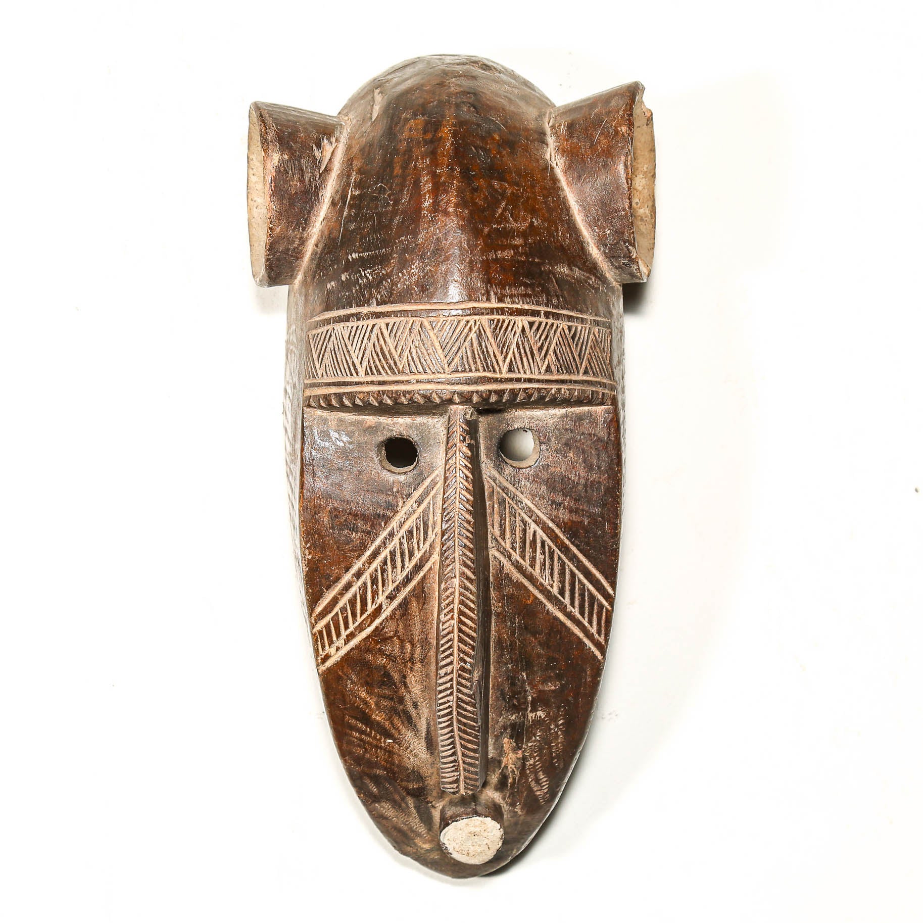 Wooden mask with intricate carvings on a white background
