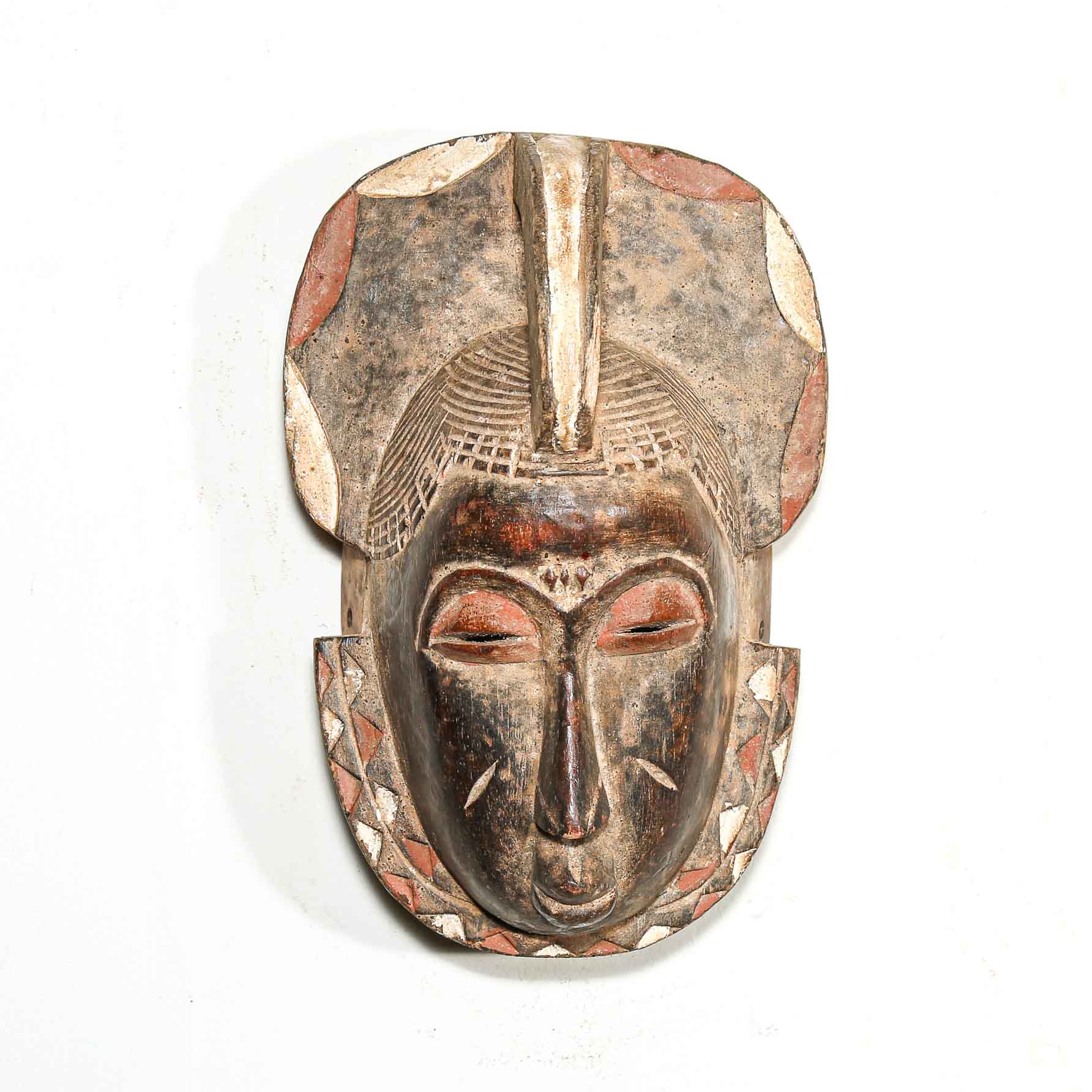 Wooden mask with intricate carvings on a white background