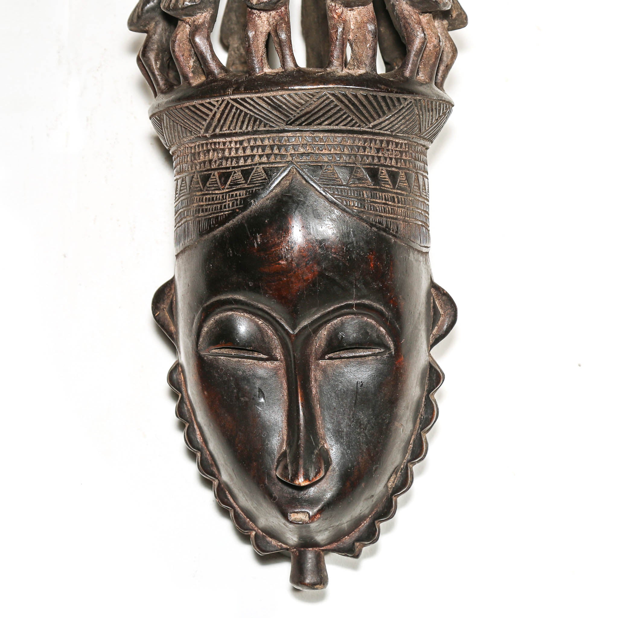 African mask with detailed carvings on a white background