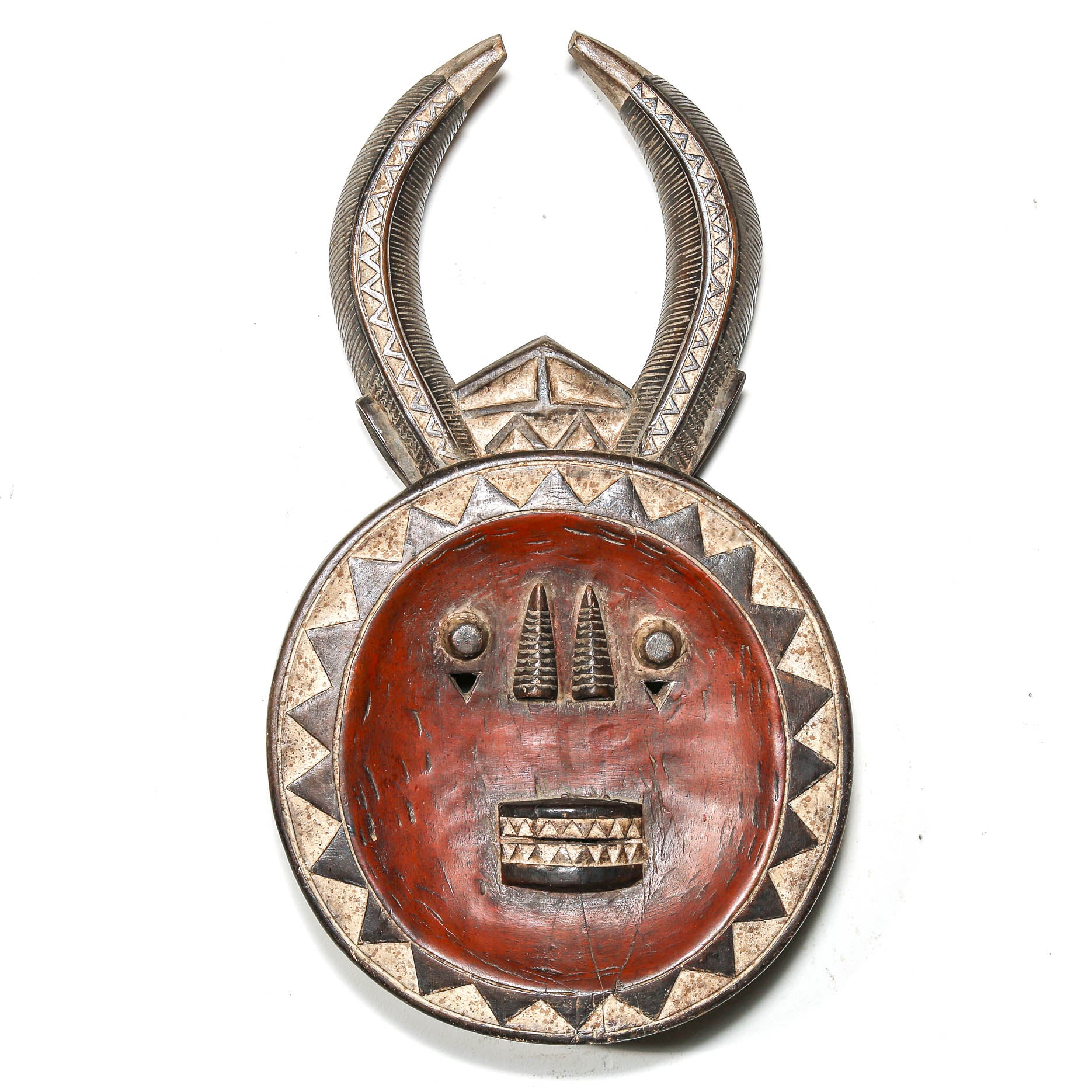 Decorative tribal African mask with horn-like structures on a white background