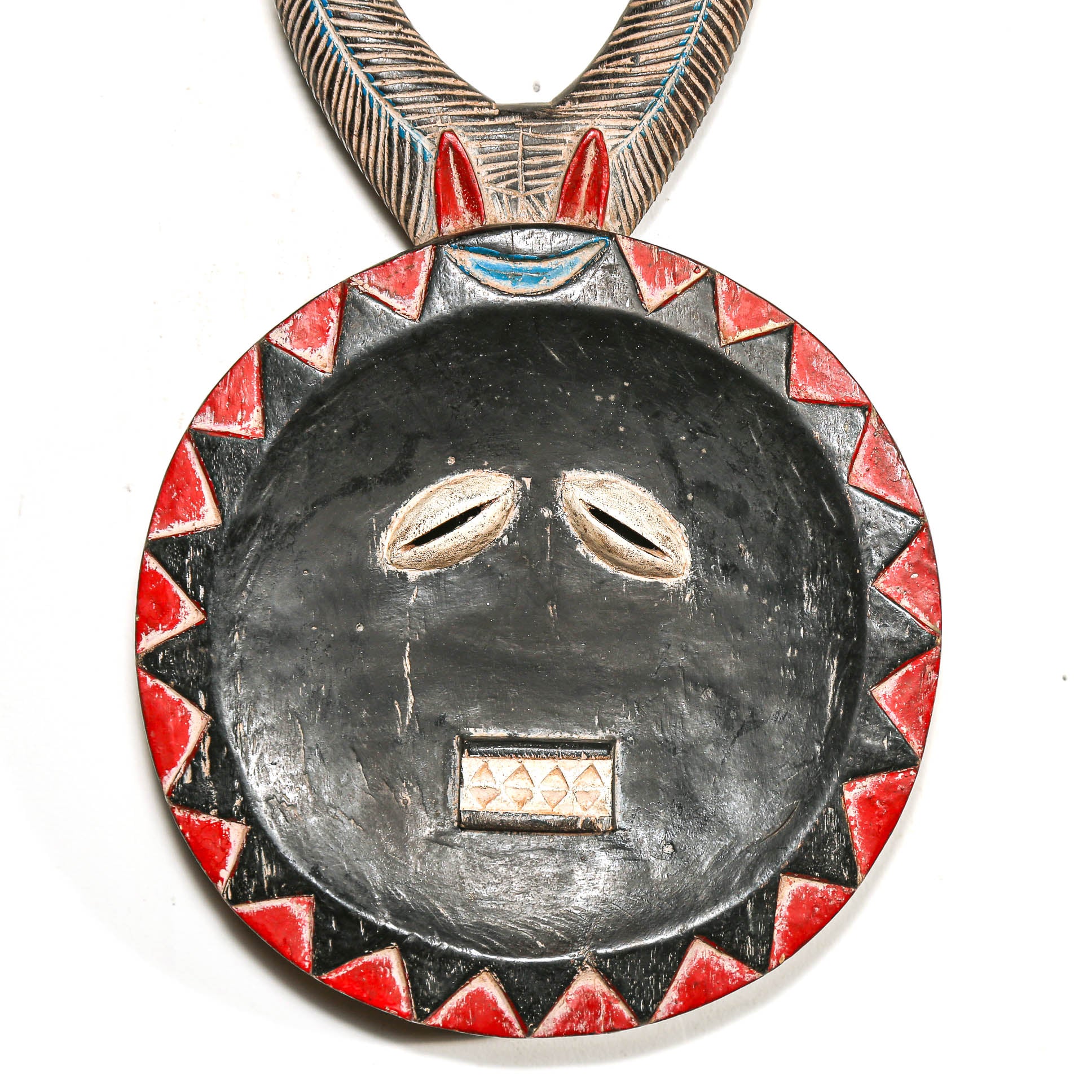 Decorative pendant with black face design and red and black geometric patterns on a white background