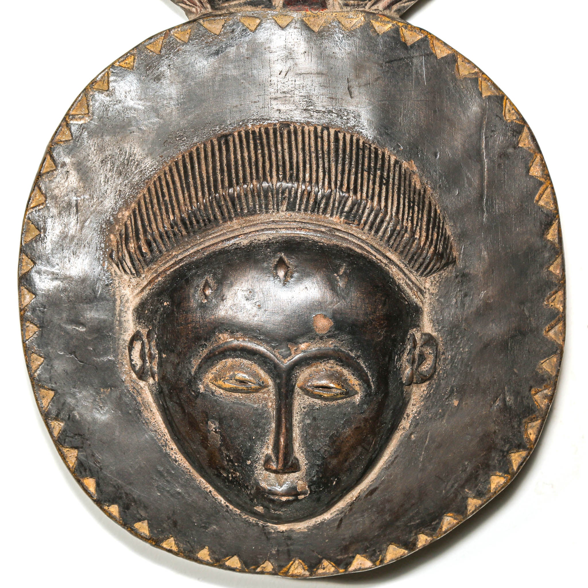 Decorative black African art mask with face design on a white background