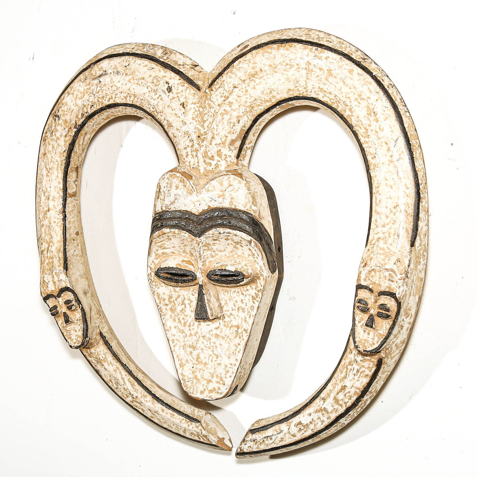 Decorative wall hanging African mask with a heart shape and black lines on a white background