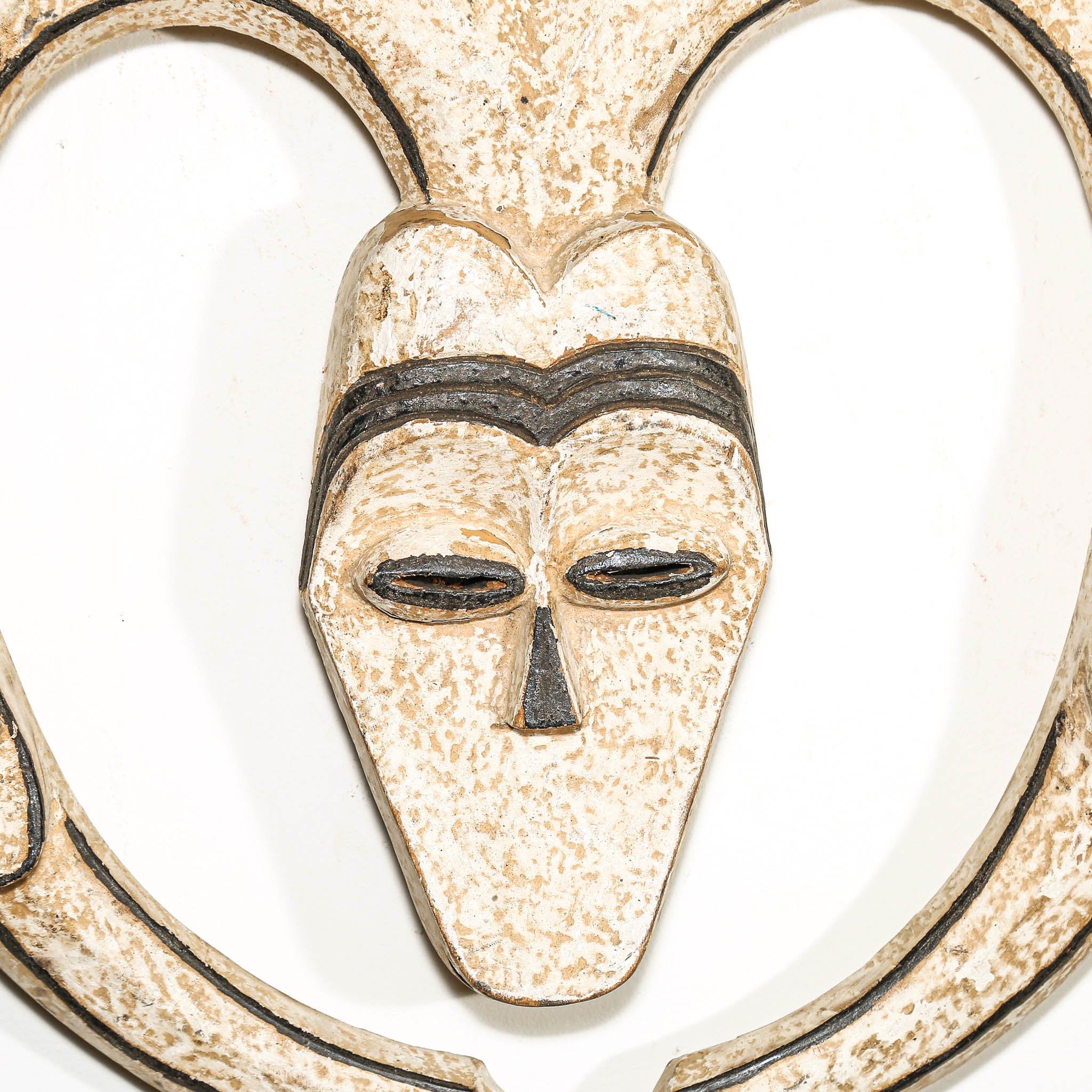 Decorative wall hanging African mask with a heart shape and black lines on a white background