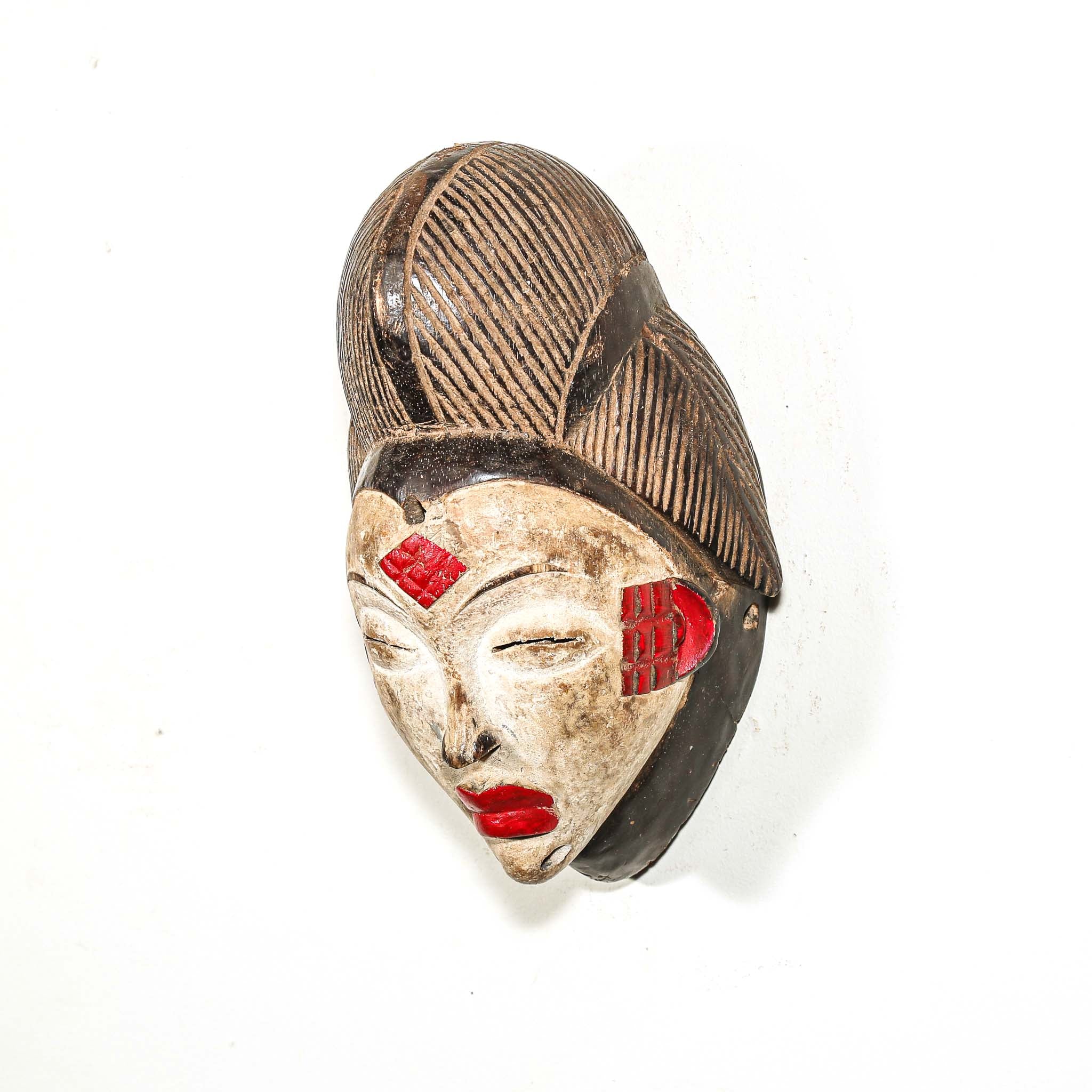 African mask with red accents on a white background