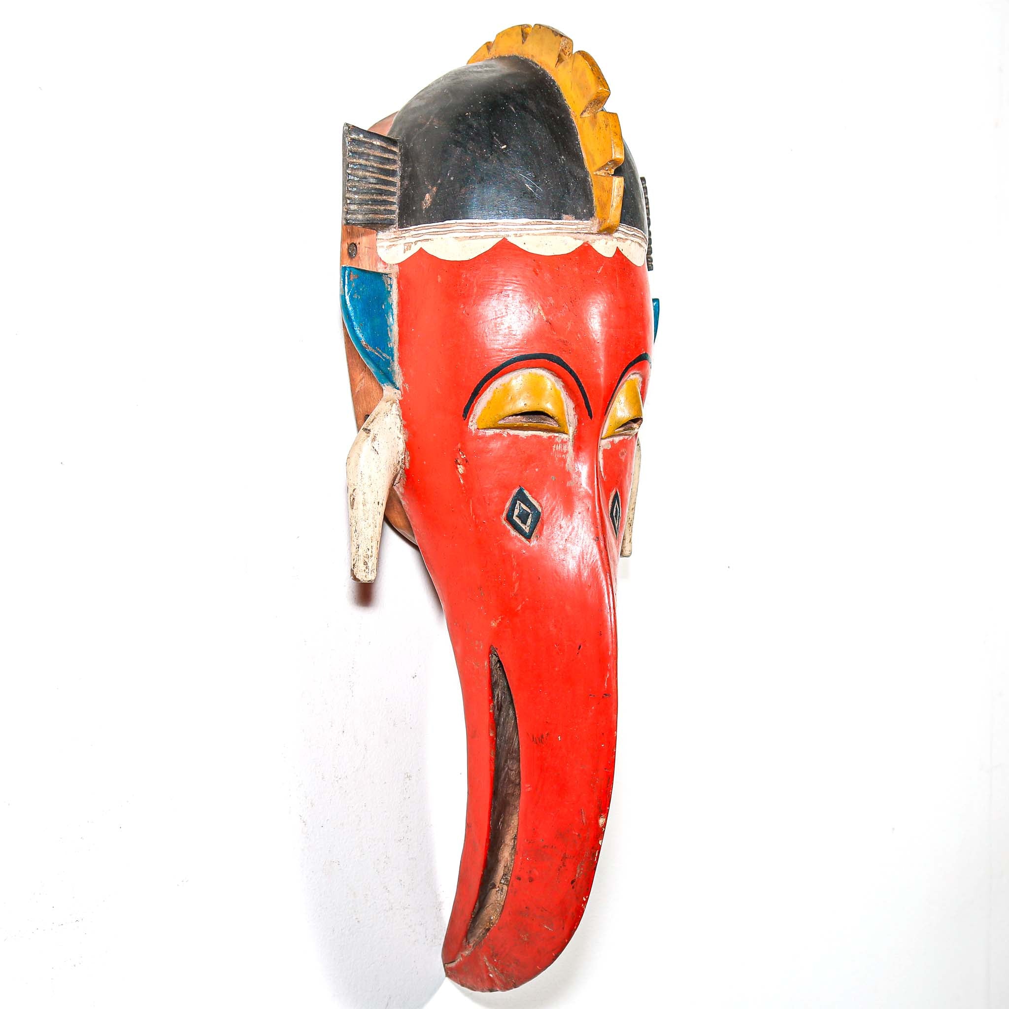 Colorful mask with a long bird beak on a white background spiritual African art