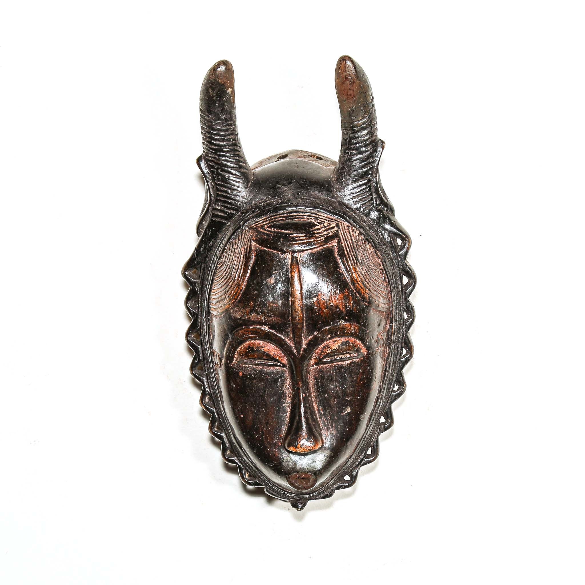 brown and black African mask with horns on a white background