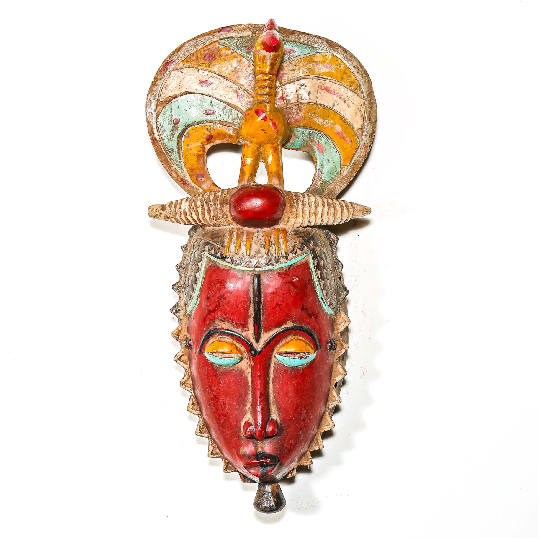 Colorful tribal wooden mask with intricate designs and animals on a white background